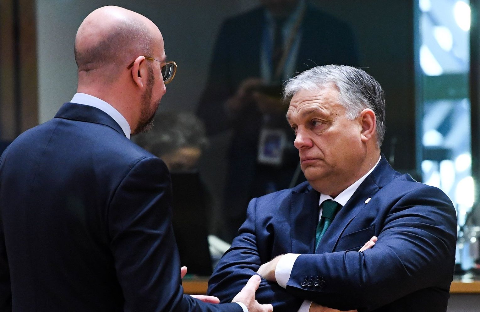 Przewodniczący Rady Europejskiej Charles Michel rozmawia z węgierskim prermierem Viktorem Orbanem w siedzibie RE w Brukseli. Michel stoi tyłem, mówi coś do Organa, który patrzy w bok z założonymi rękami.