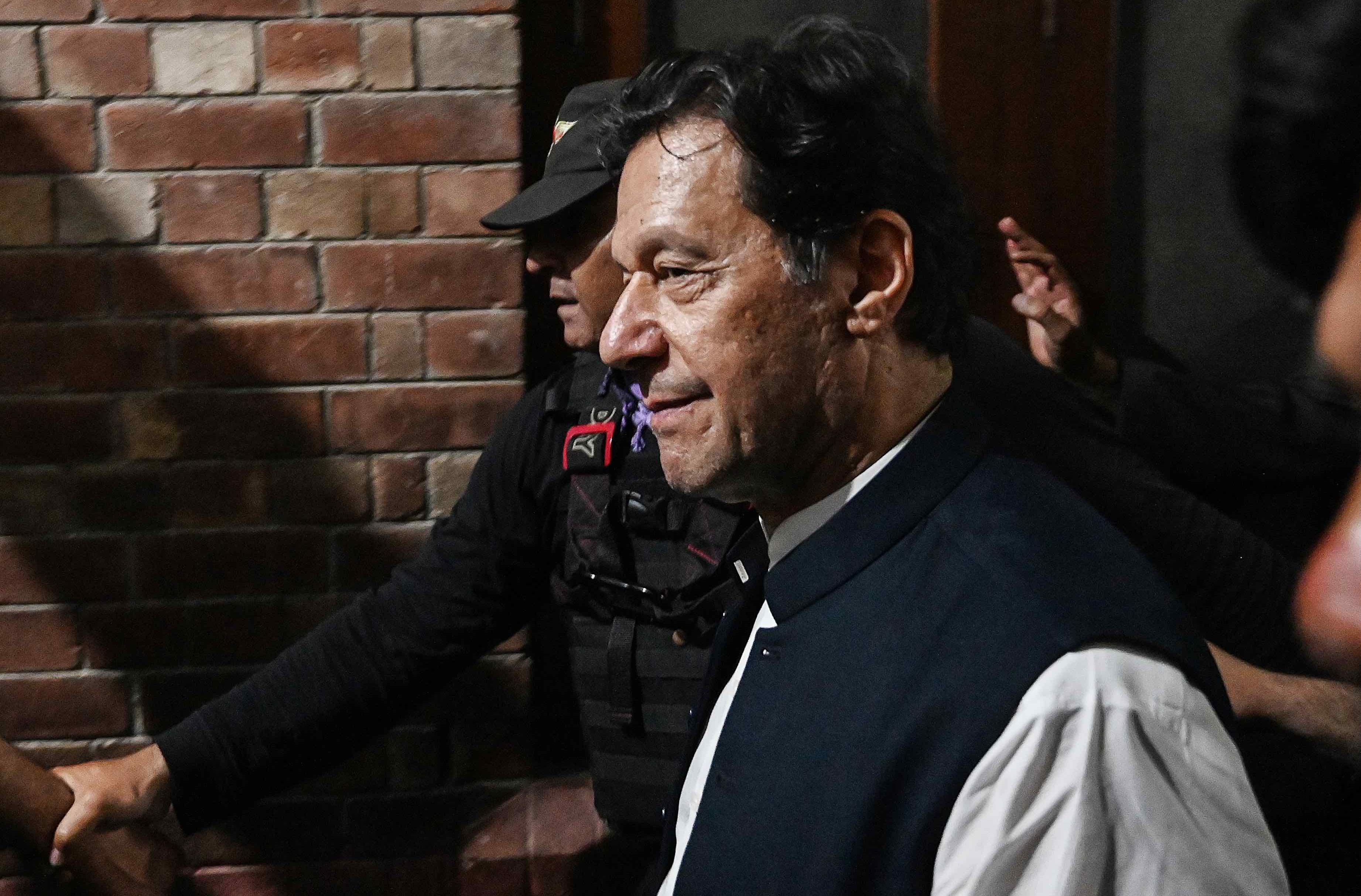 Były premier Pakistanu Imran Khan w otoczeniu swoich zwolenników i ochroniarzy wychodzi z budynku sądu. Pakistan w kryzysie.