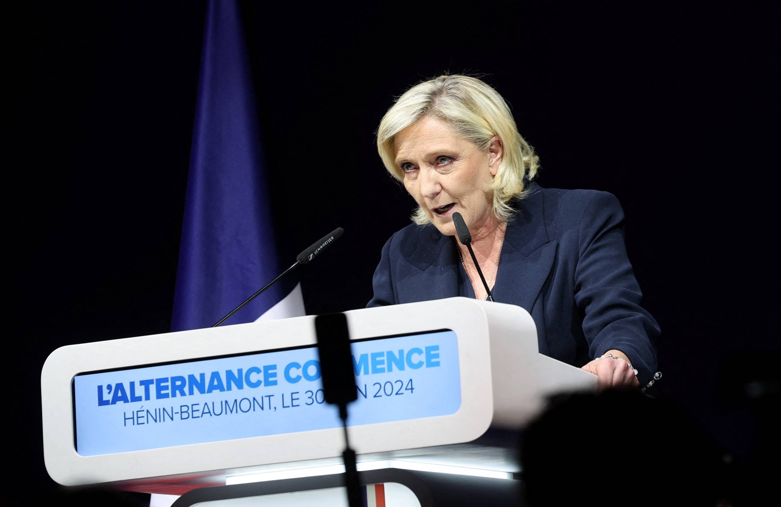 Marine Le Pen pochyla się nad mównicą w wyborczy wieczór
