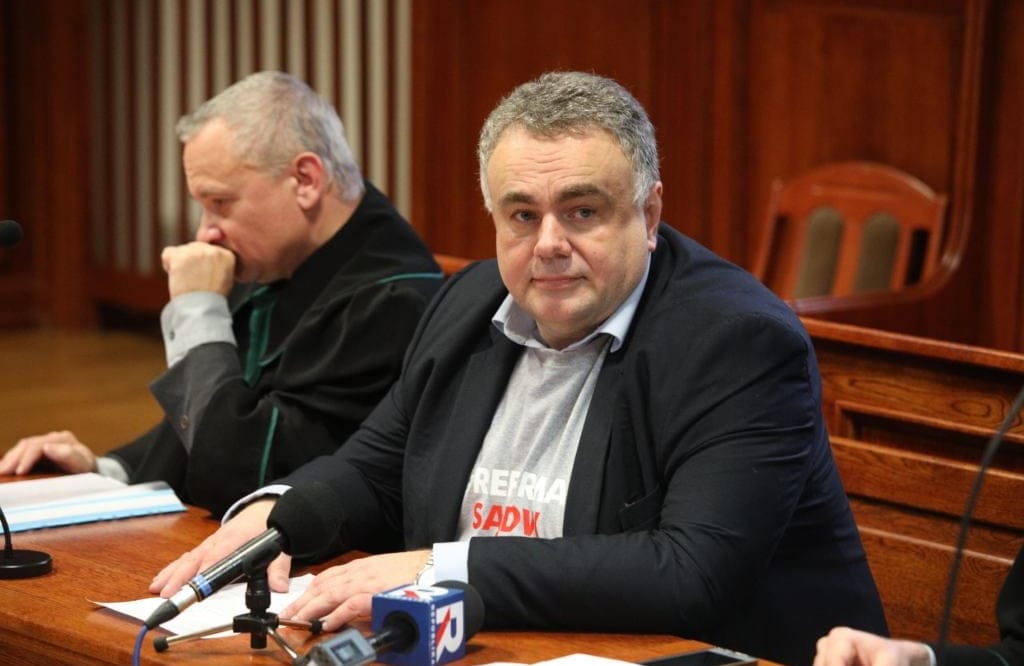 Dwaj mężczyźni siedzą za stołem w sali sądowej, jeden z nich to Tomasz Sakiewicz