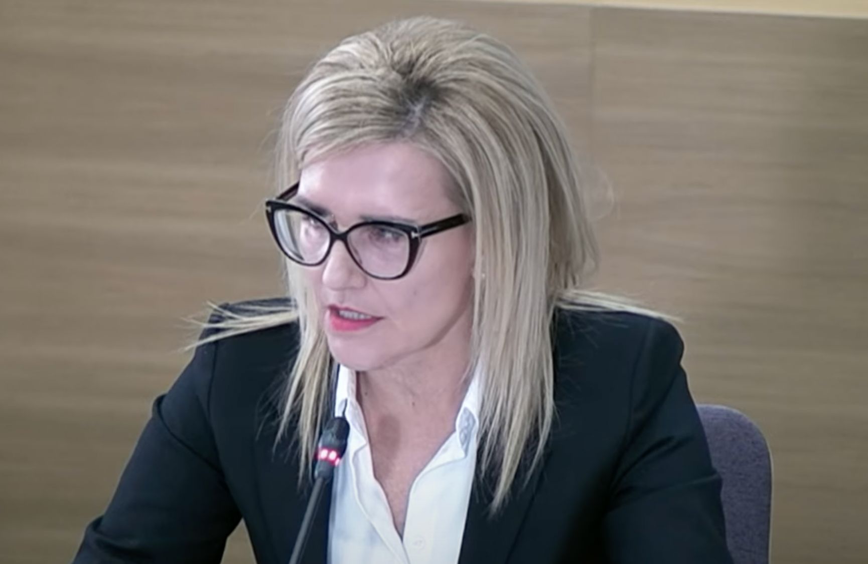 Ewa Wrzosek w białej koszuli i ciemnej marynarce odpowiada na pytania przed komisją ds. wyborów kopertowych