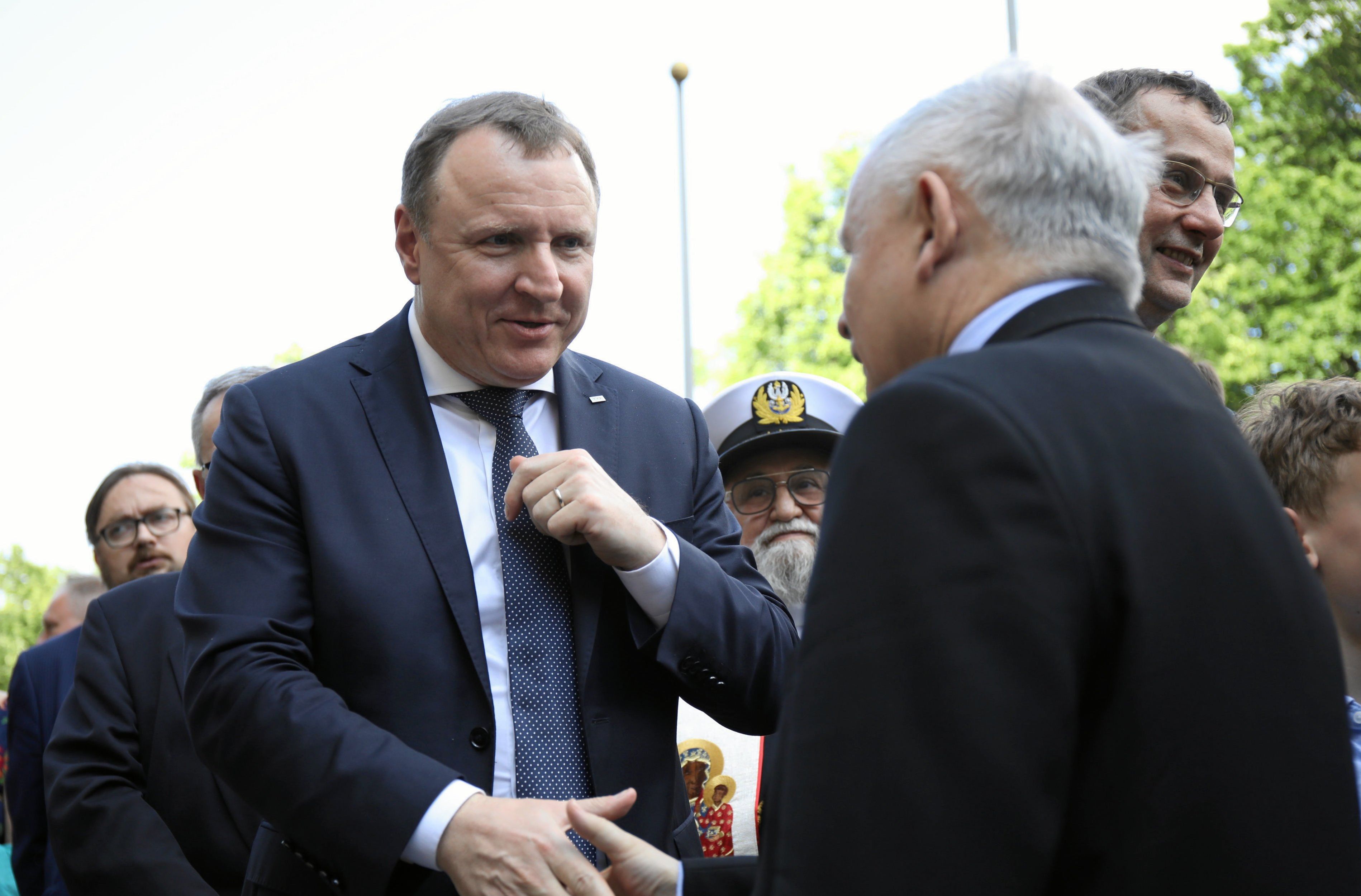 Dwaj mezczyźni w garnitirach. Jacek Kuski z uniżeniem ściska dłon Jarosława Kaczyńskiego