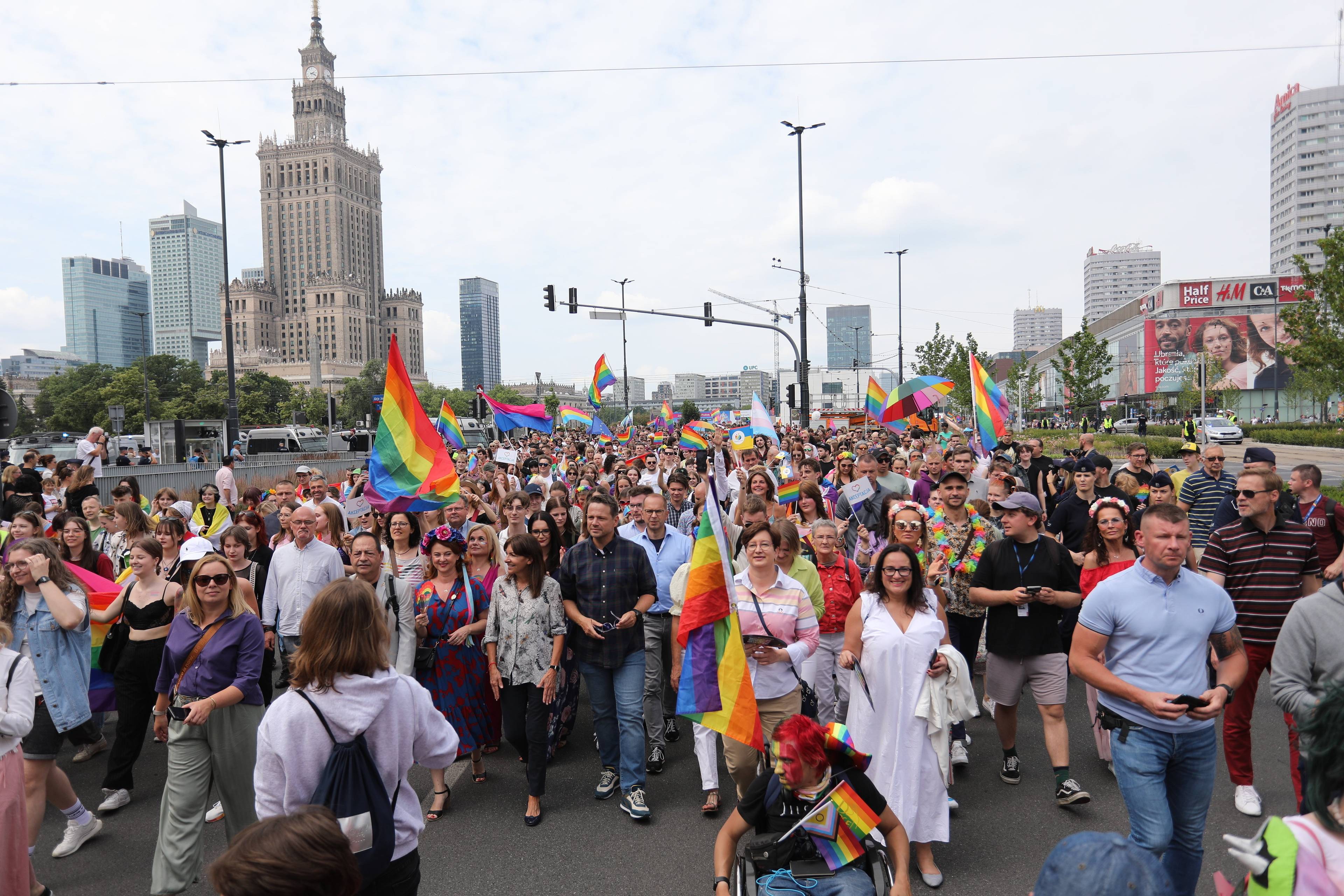 TŁUM OSÓB Z TĘCZOWYMI FLAGAMI