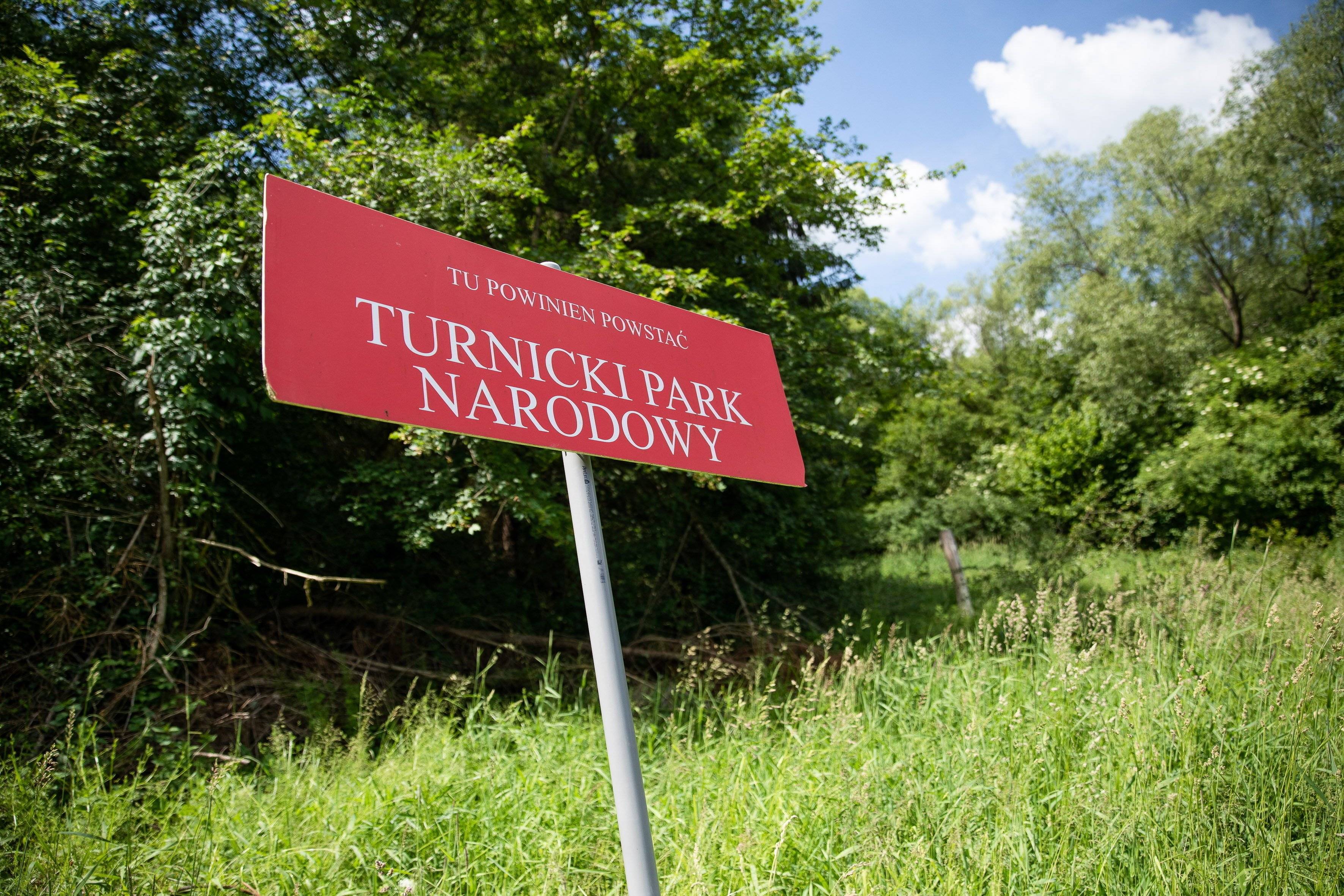 tablica z napisem "Tu powinien powstać Turnicki Park Narodowy"