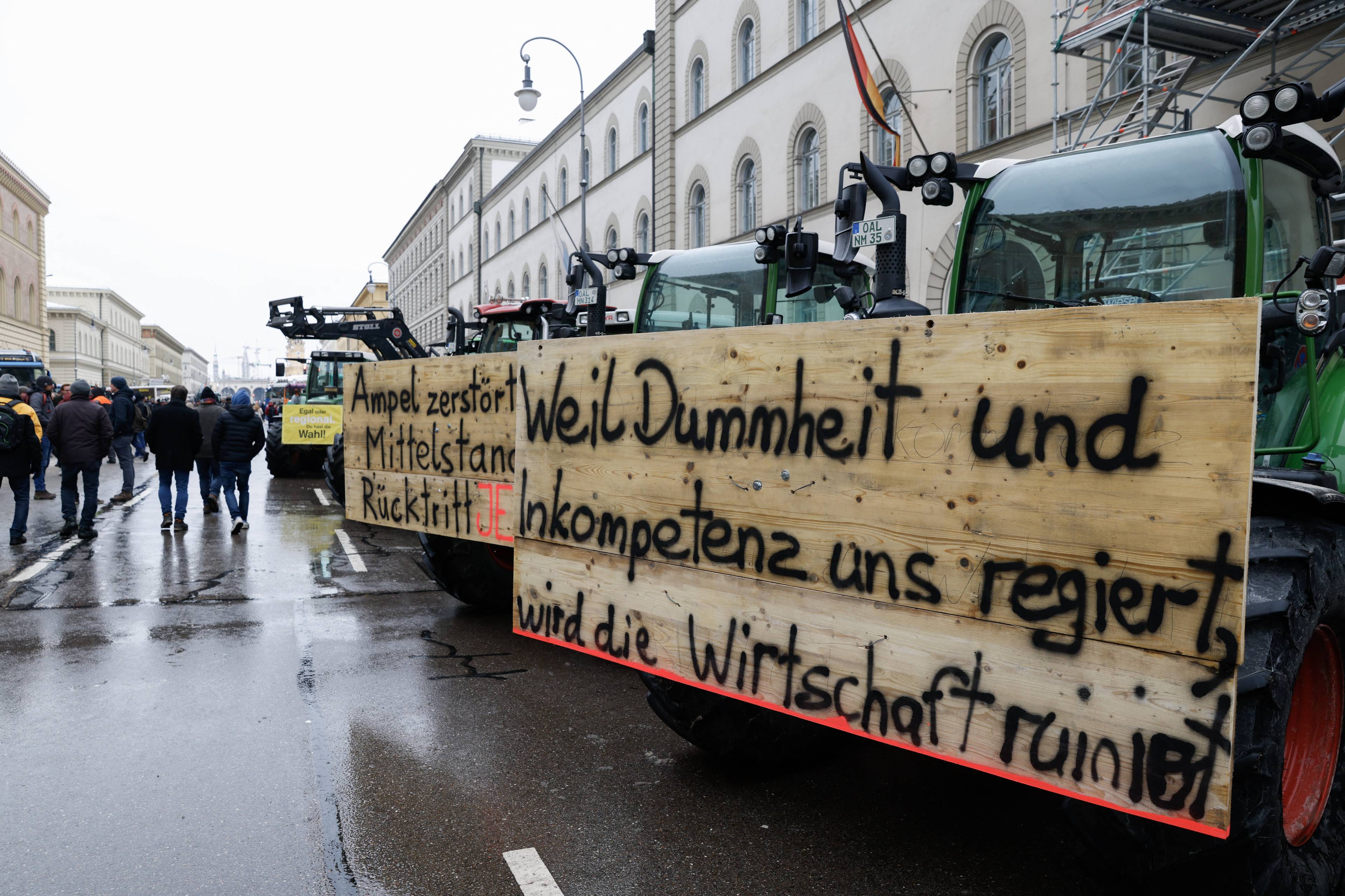 Kolumna traktorów w mieście, na nich hasło: Kiedy rządzą głupota i niekompetencja, gospodarka jest w ruinie. Niemiecka gospodarka