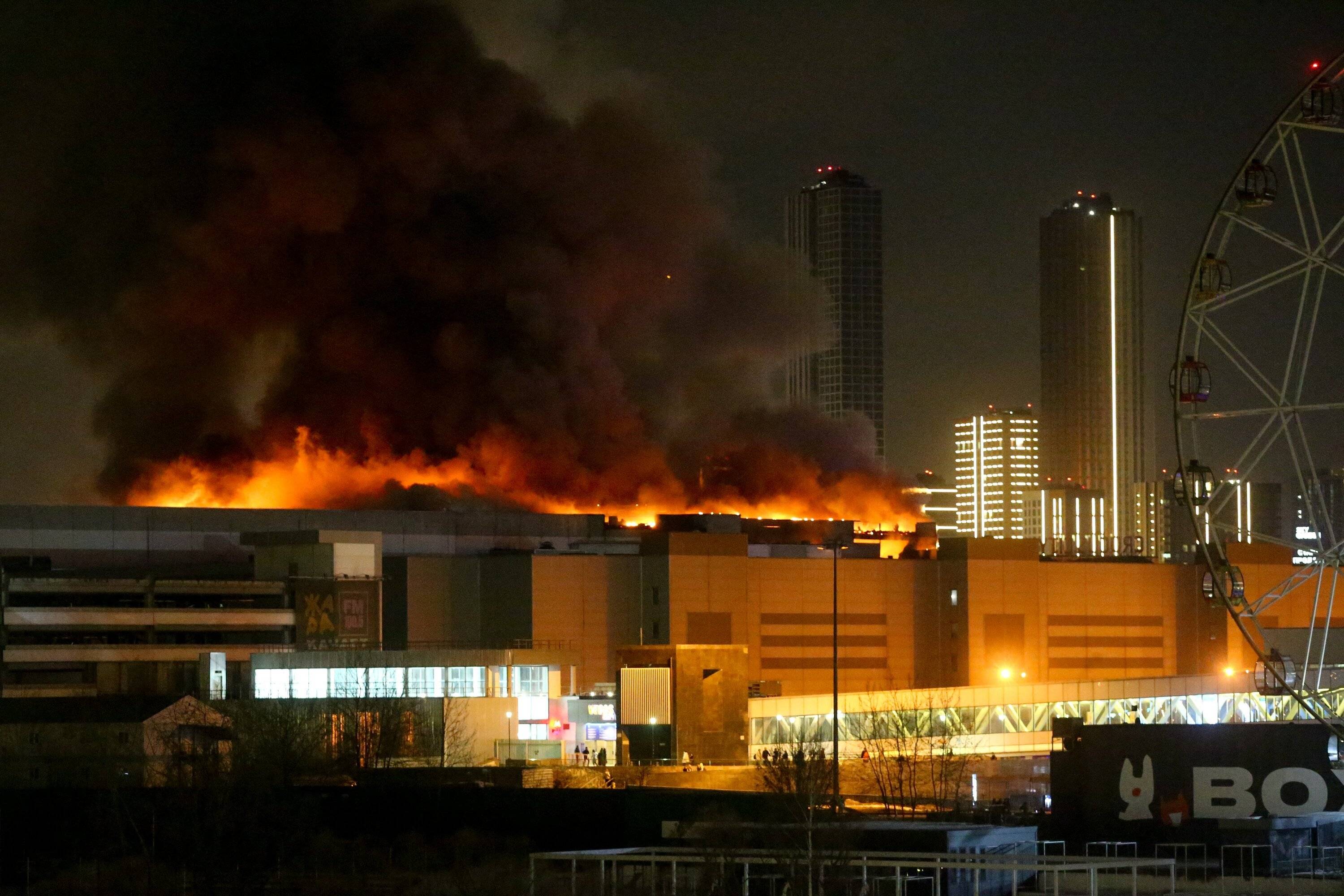 Płonące centrum handlowe, płomienie i dym widać nad dachem, rozświetlają noc