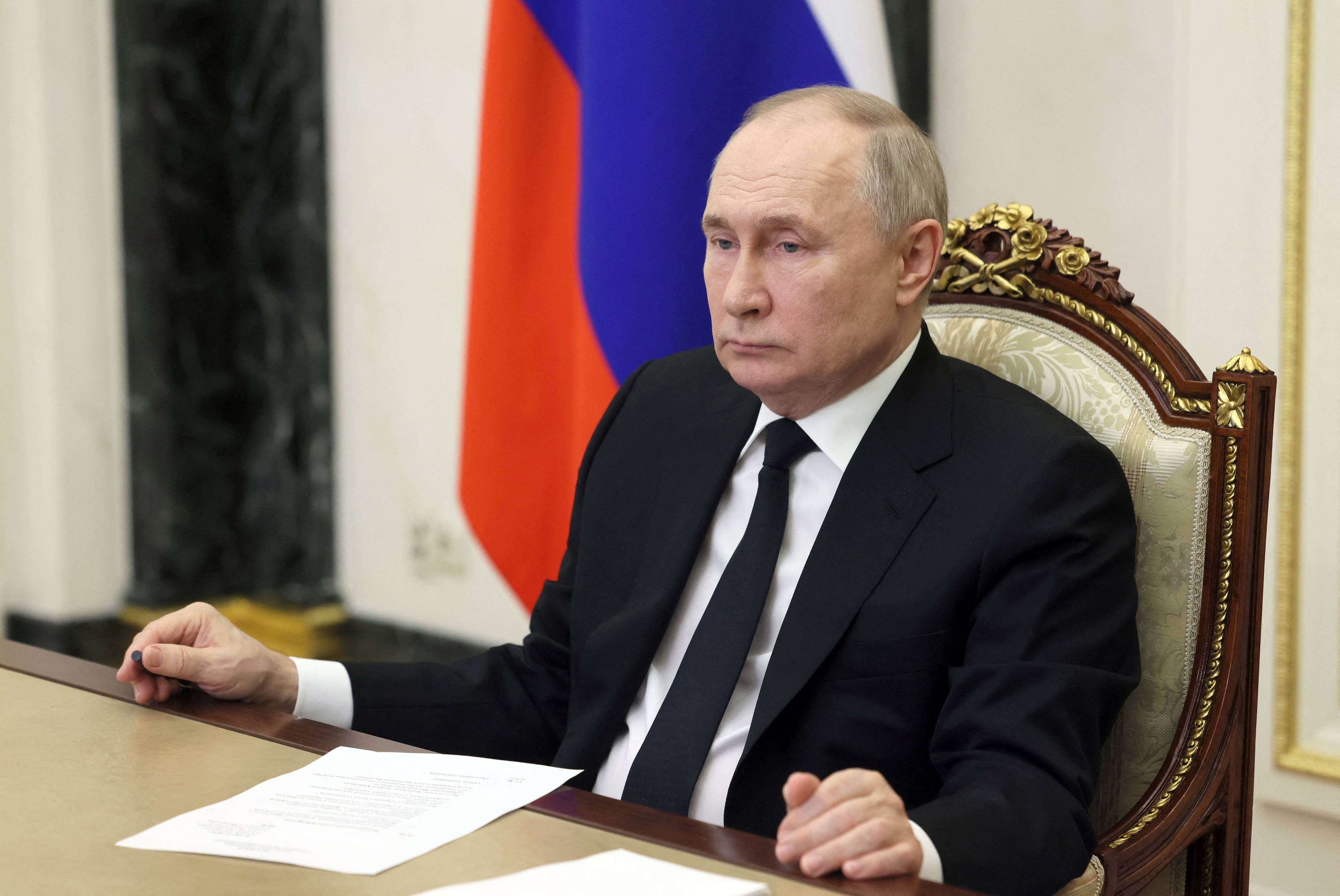 Władimir Putin siedzi za stołem
