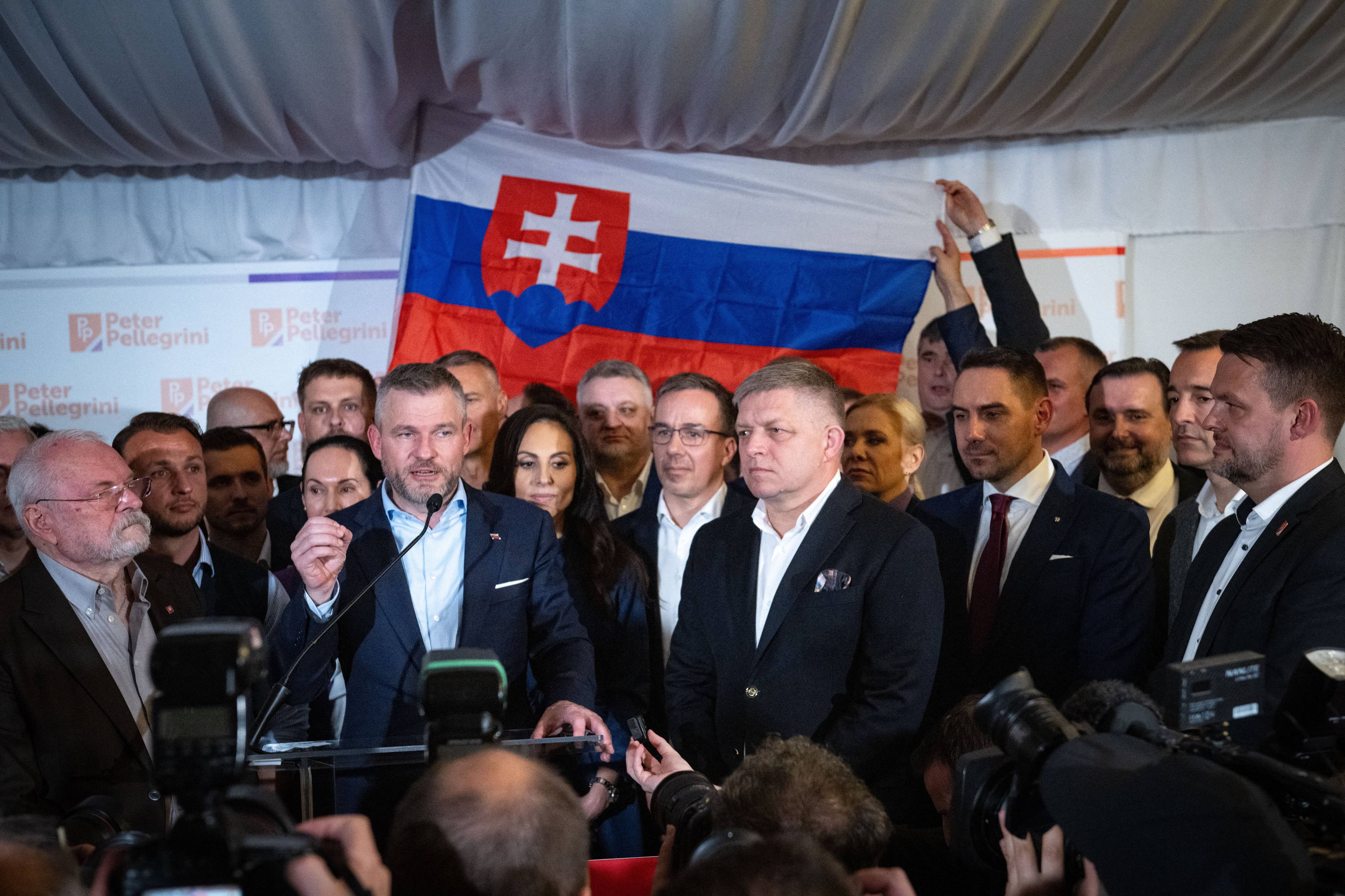 Kobiety i mężczyźni stojący przed flagą Słowacji
