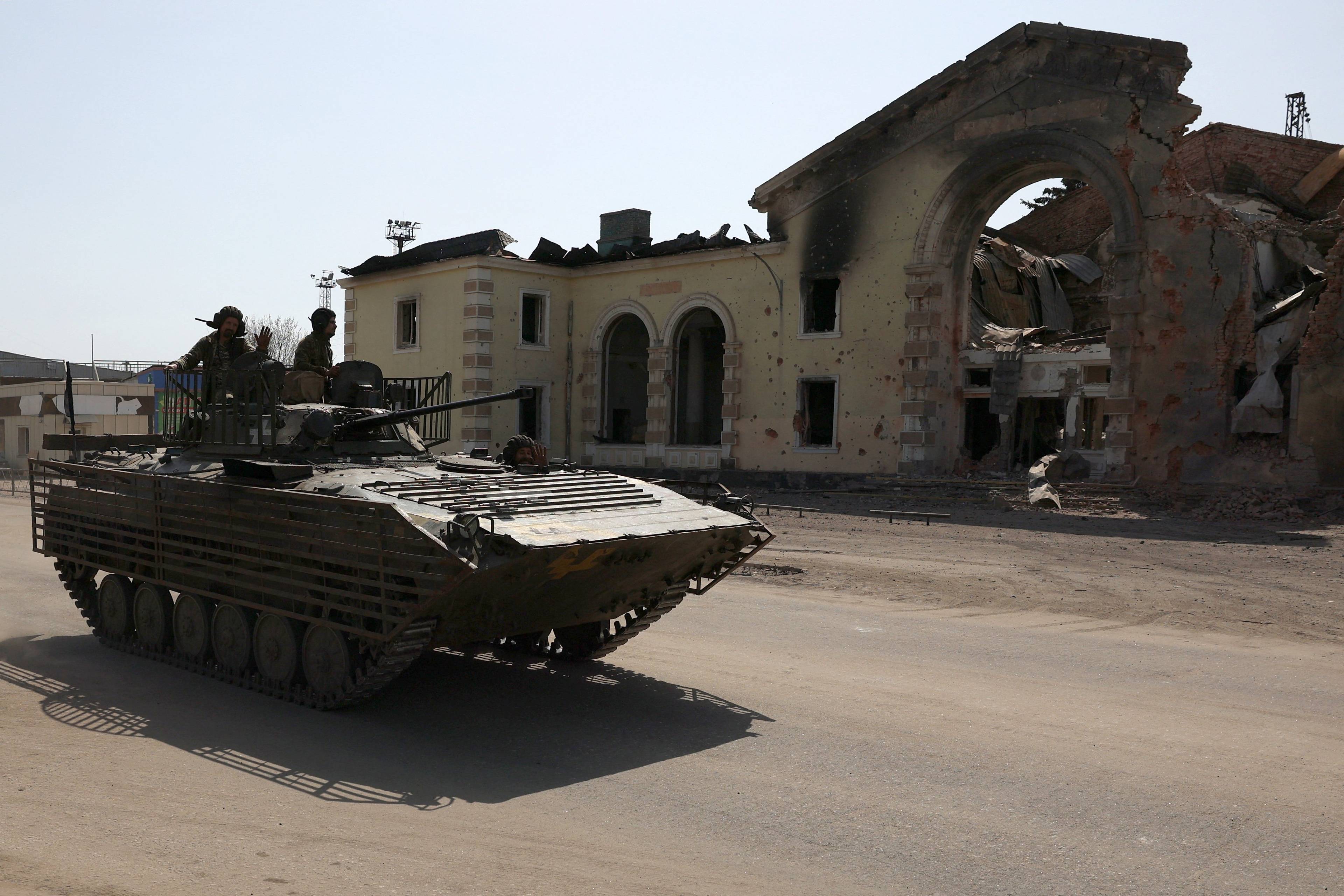 Bojowy wóz piechoty na tle zbombardowanego budynku