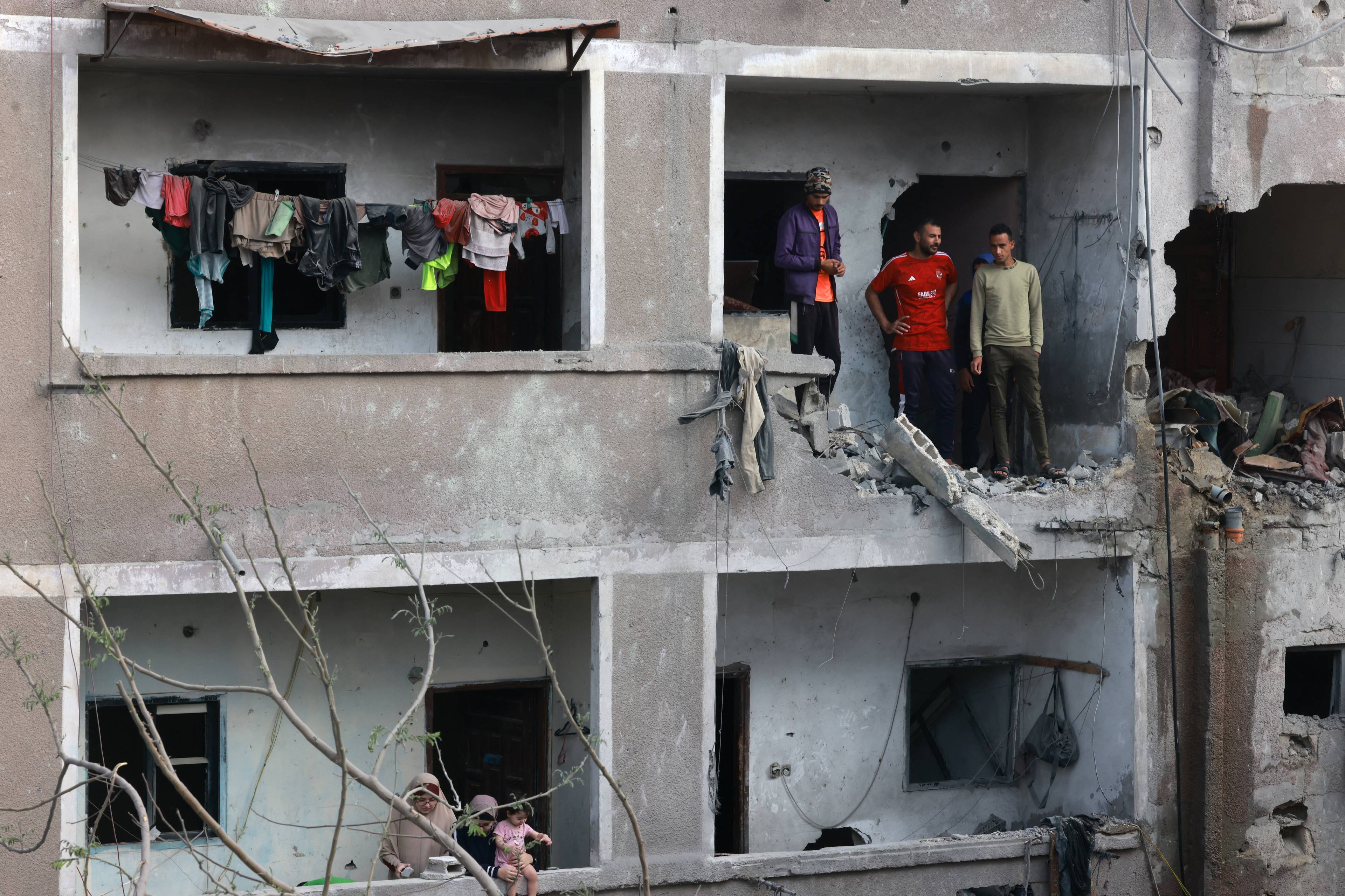 kilka osób stoi w zbombardowanym budynku