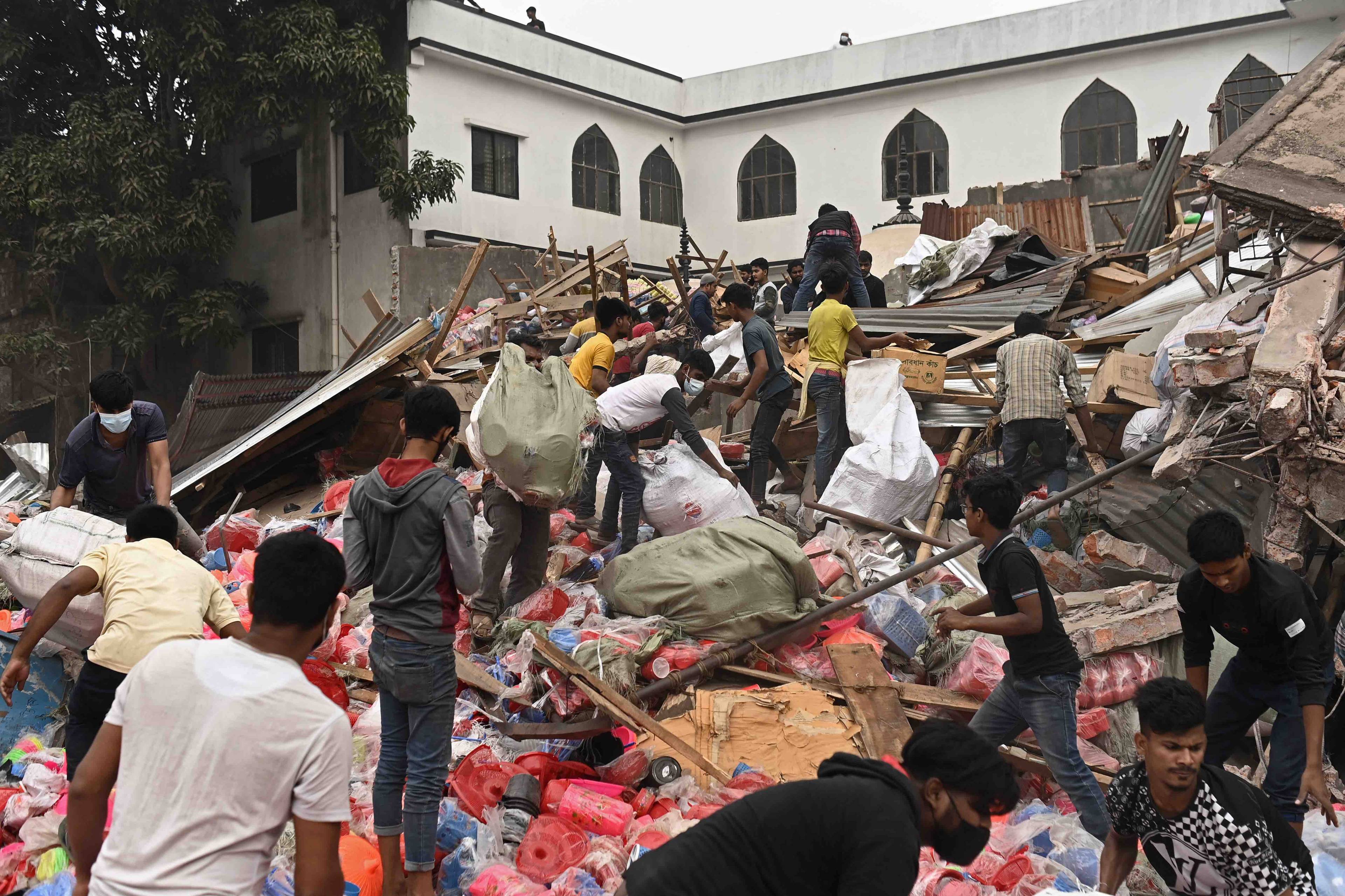 Ludzie szukają rzeczy wśród szczątków zburzonych domów. Bangladesz