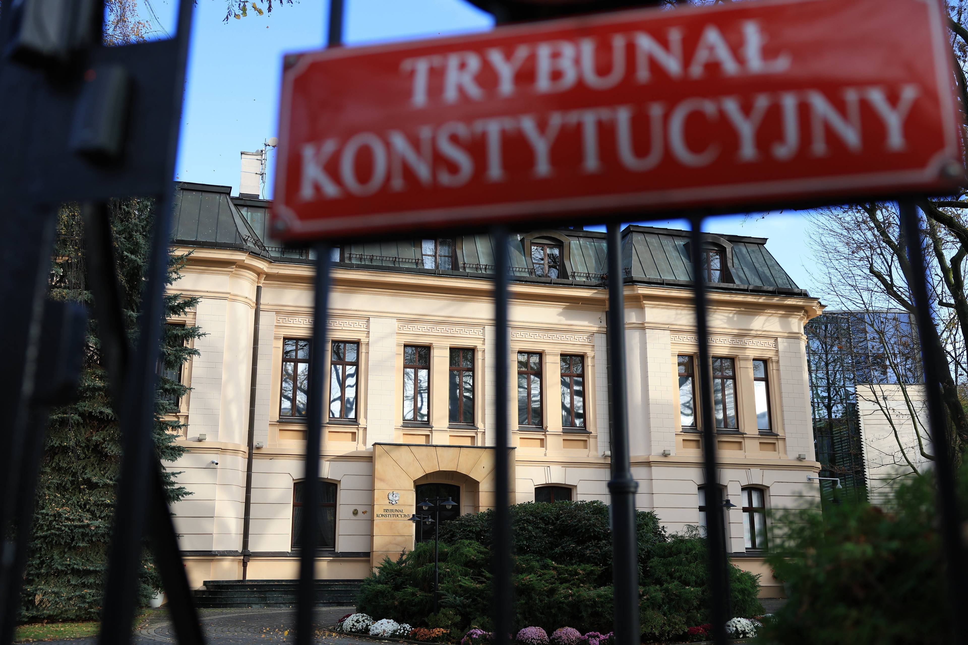 Tablica z napisem Trybunał Konstytucyjny na płocie , w tle budynek TK