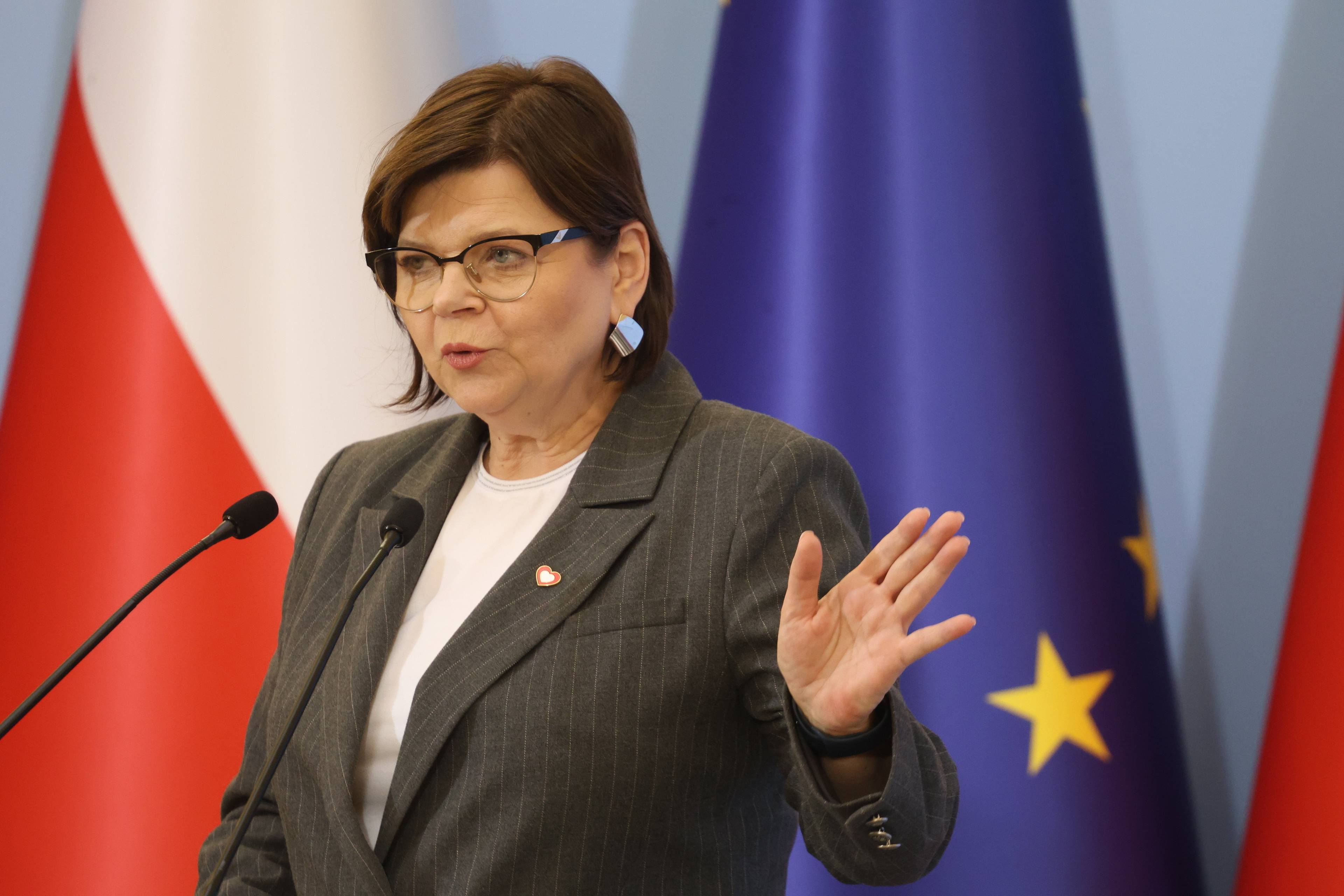 Ministra Izabela Leszczyna przemawia na tle flagi polskiej i UE. Pigułka „dzień po”