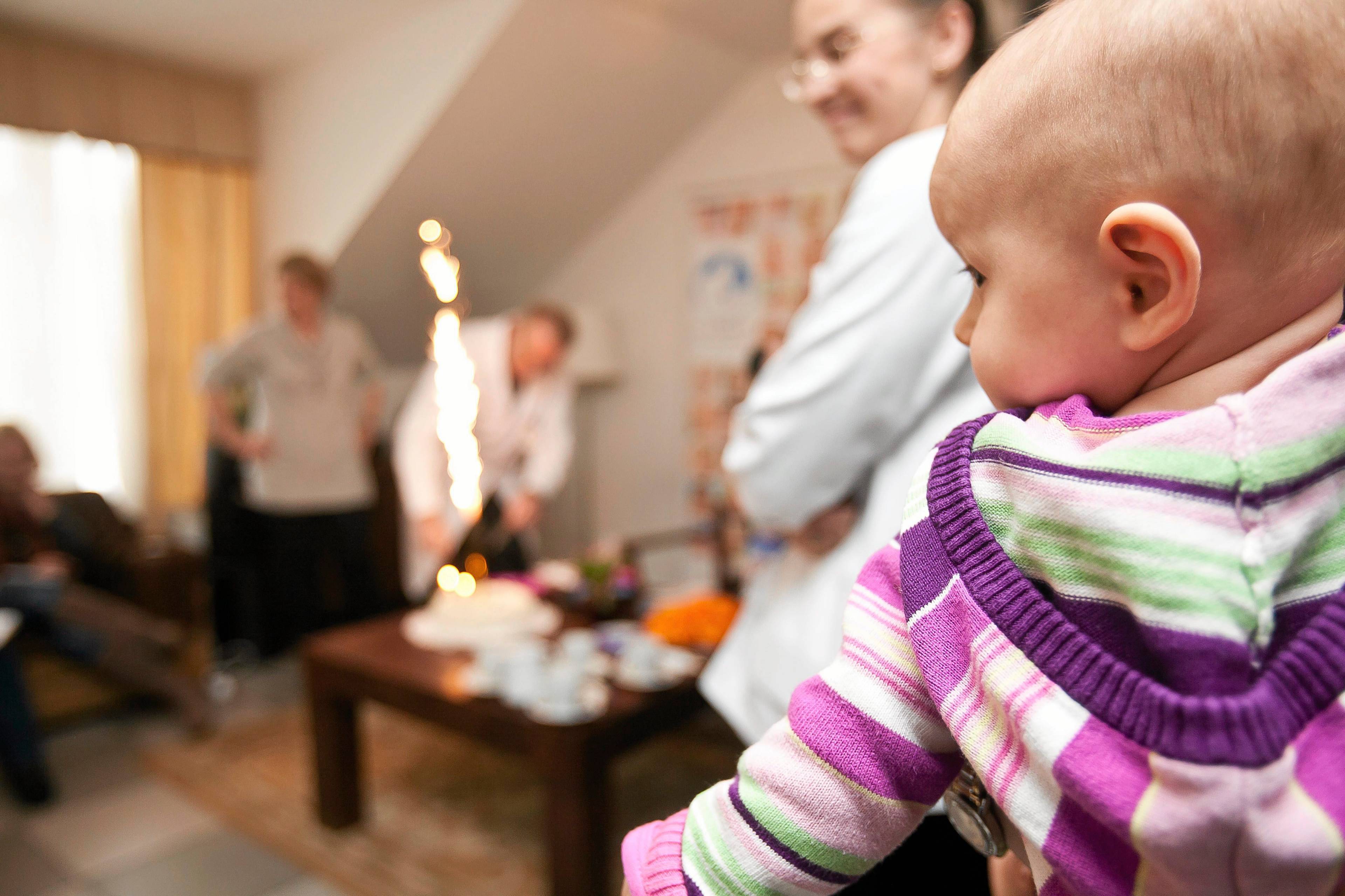 Kobieta z niemowlakiem na ręku świętuje w klinice z medykami