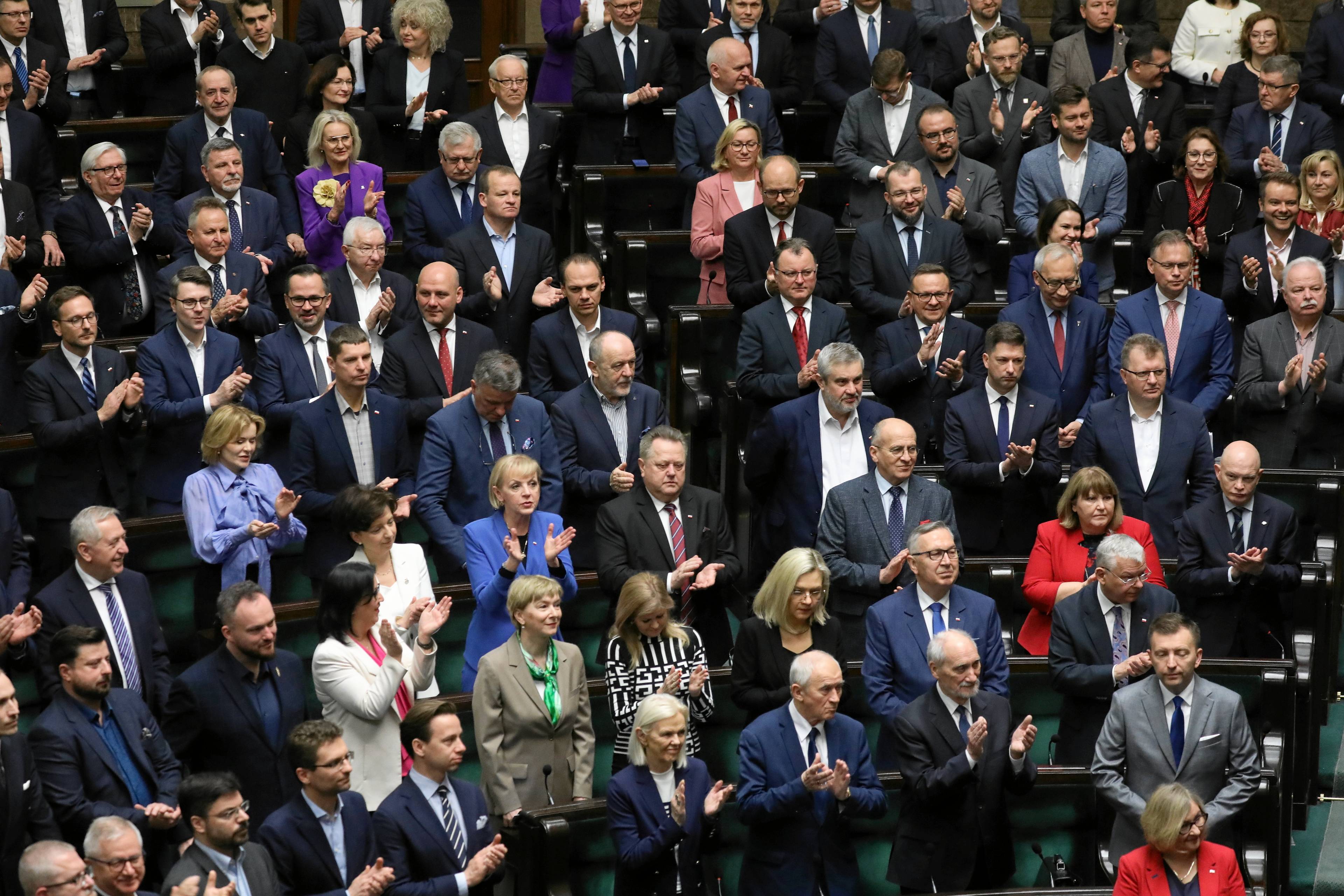 Posłowie i posłanki stoją w Sejmie