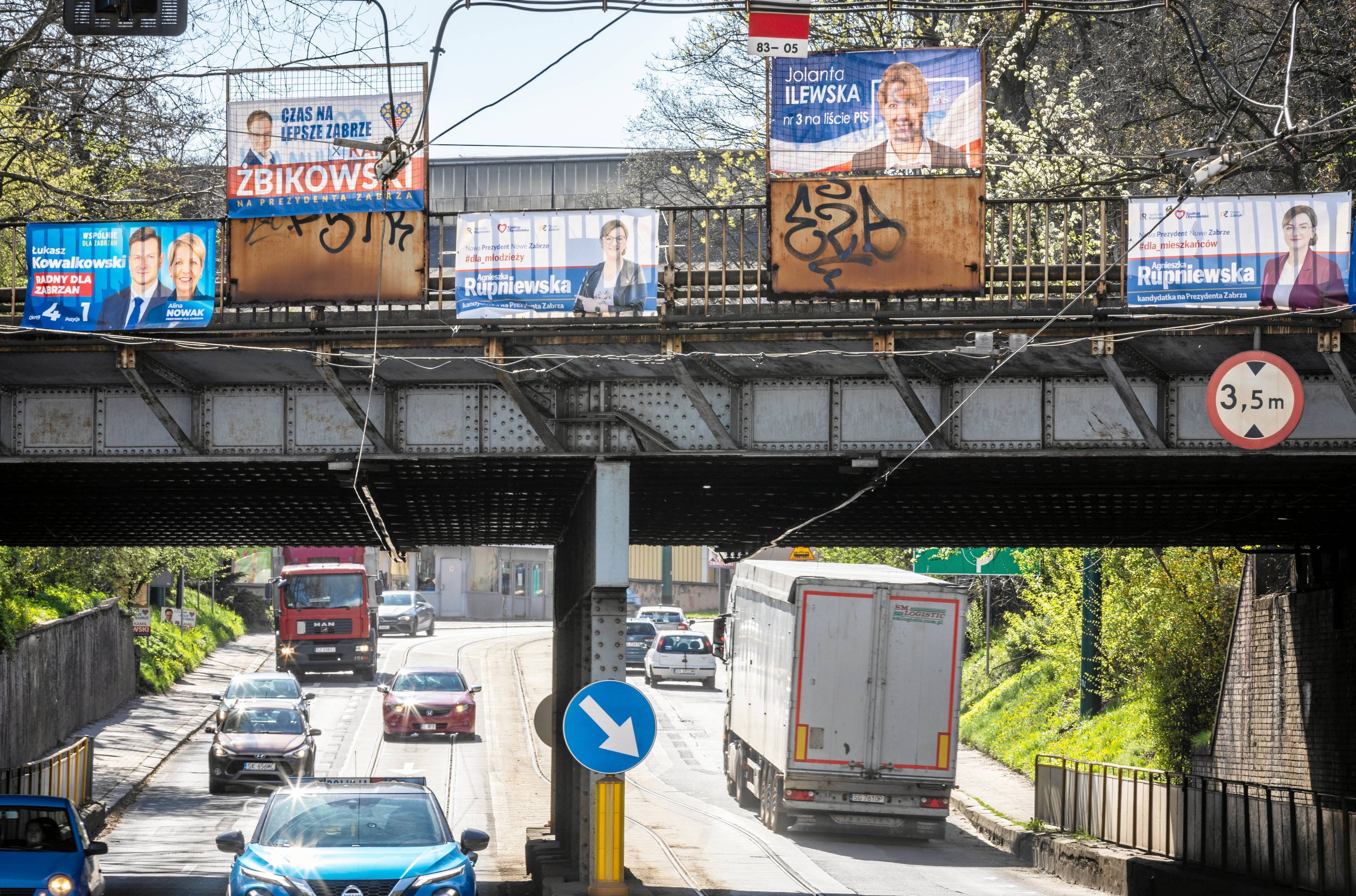 Widok na wiadukt drogowy oklejonym plakatami wyborczymi