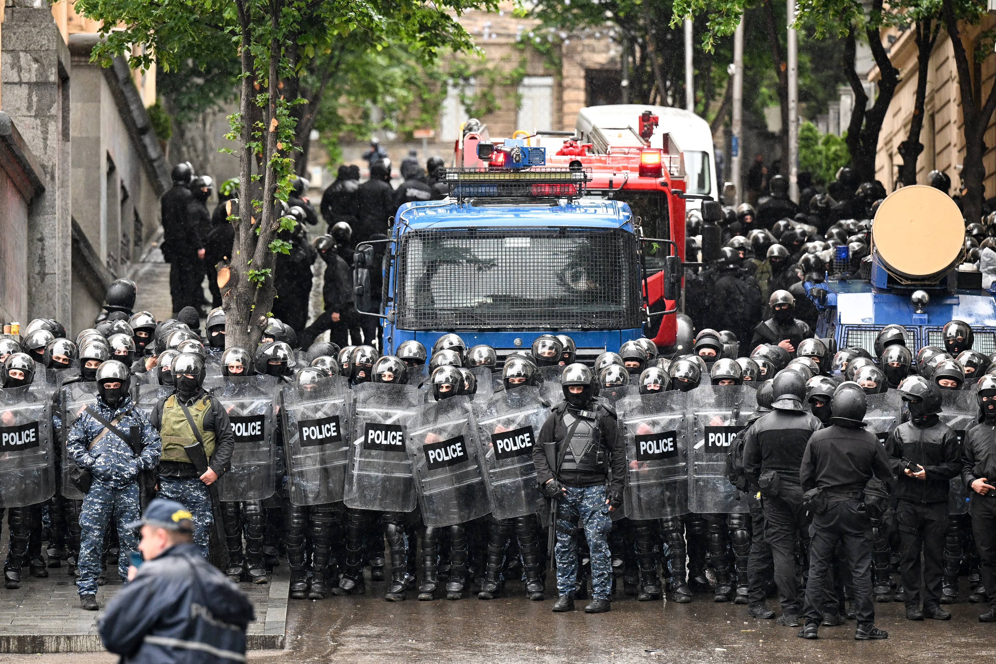 Georgian law enforcement officers are seen deployed on streets as protesters rally against the controversial "foreign influence" bill in Tbilisi on May 14, 2024. - Georgia's parliament on May 14, 2024 adopted a controversial "foreign influence" law that has sparked weeks of mass protests against the measure, denounced as mirroring Russian legislation used to silence dissent. The bill requires non-governmental organisations and media outlets that receive more than 20 percent of their funding from abroad to register as bodies "pursuing the interests of a foreign power." (Photo by Vano SHLAMOV / AFP)