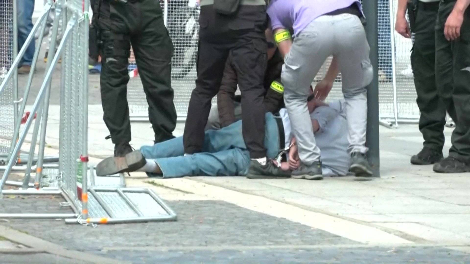This image taken from video footage obtained by AFPTV shows security personnel apprehending a suspected gunman (C/GROUND) after Slovakia's Prime Minister was shot in Handlova on May 15, 2024. - Slovakia's Prime Minister Robert Fico was battling life-threatening wounds after officials said he was shot multiple times in an assassination attempt condemned by European leaders. (Photo by RTVS / AFP)