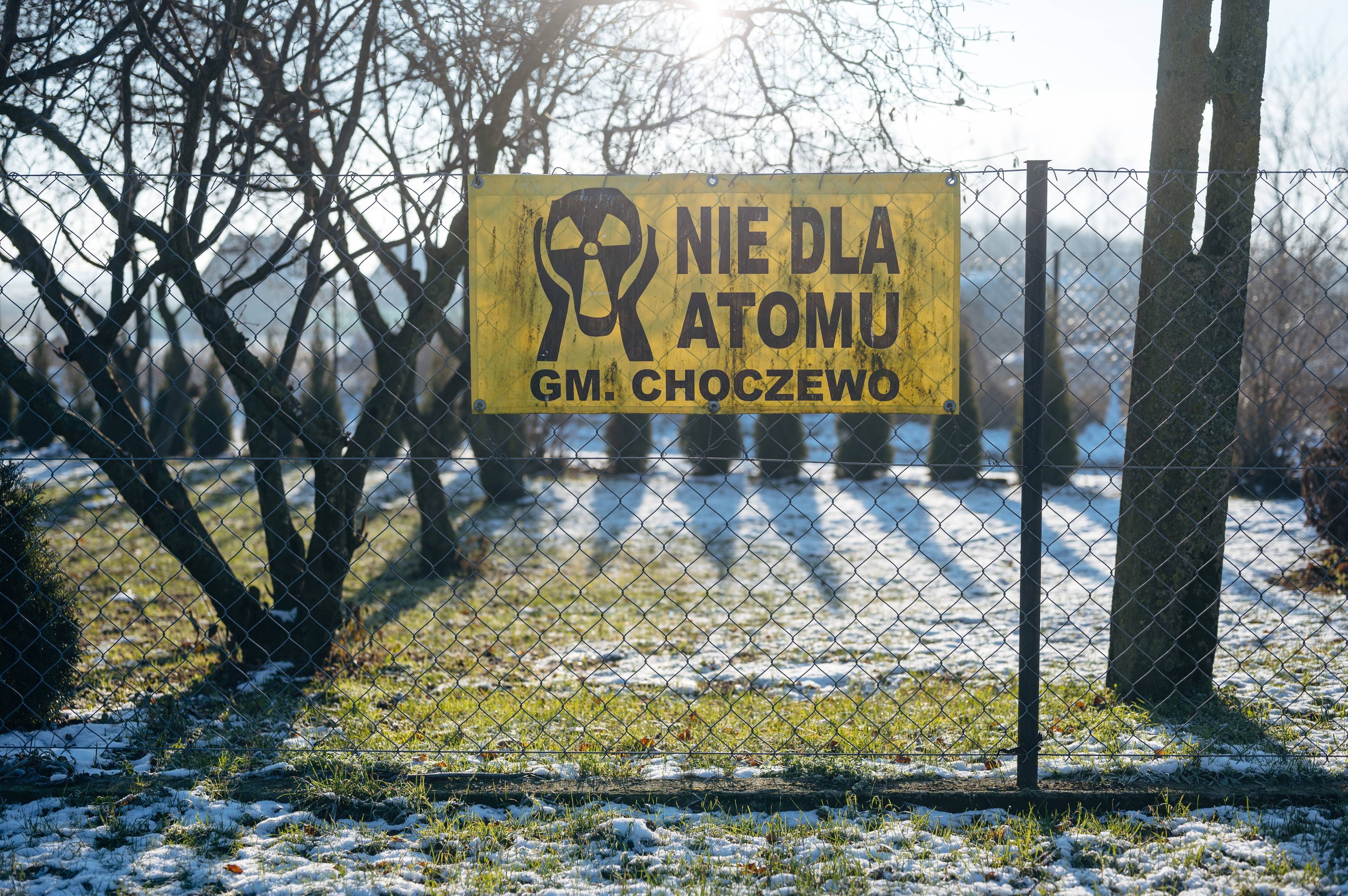 antyatomowy baner powieszony na ogrodzeniu w gminie Choczewo