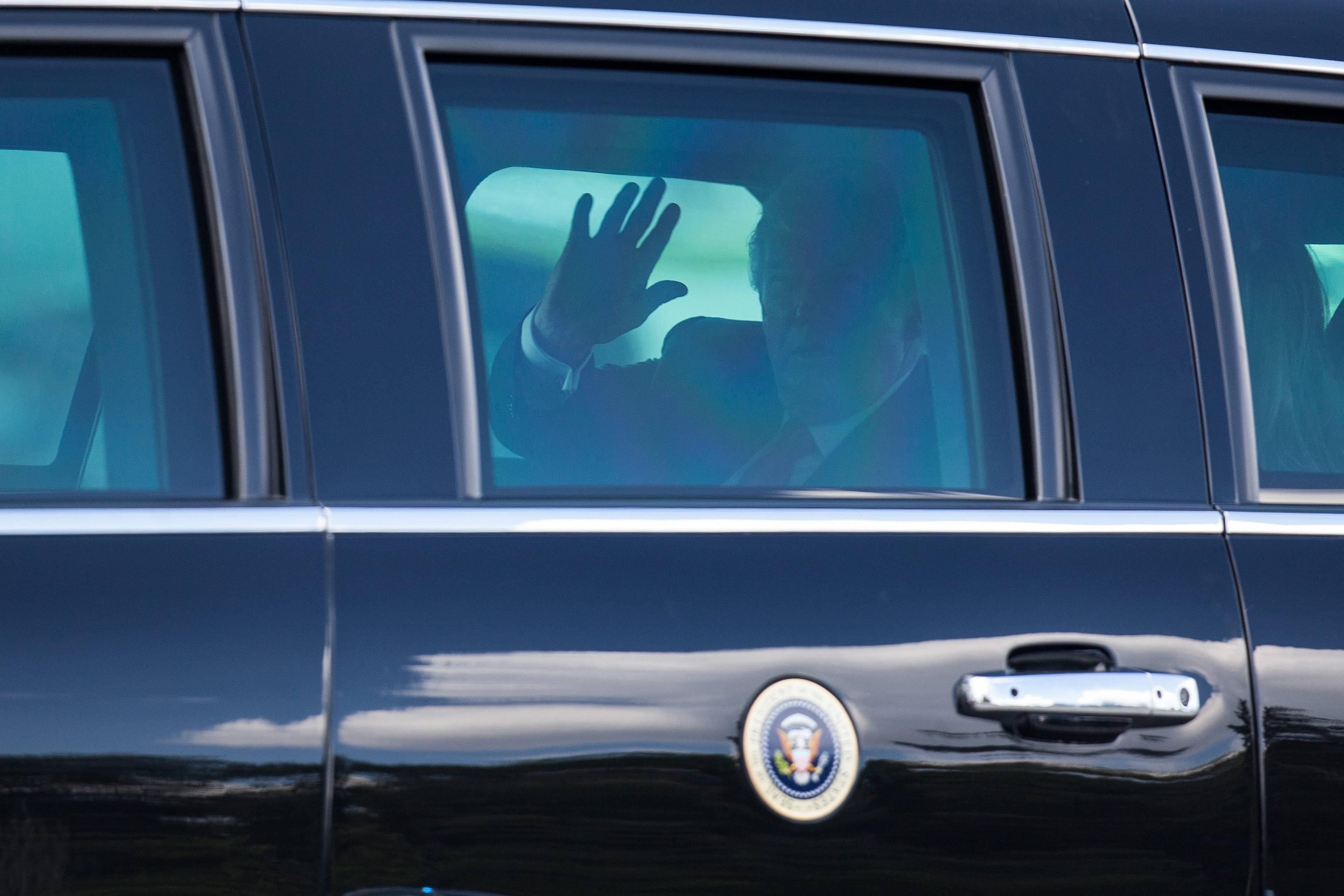 postać wewnątrz limuzyny z godłem prezydenckim USA