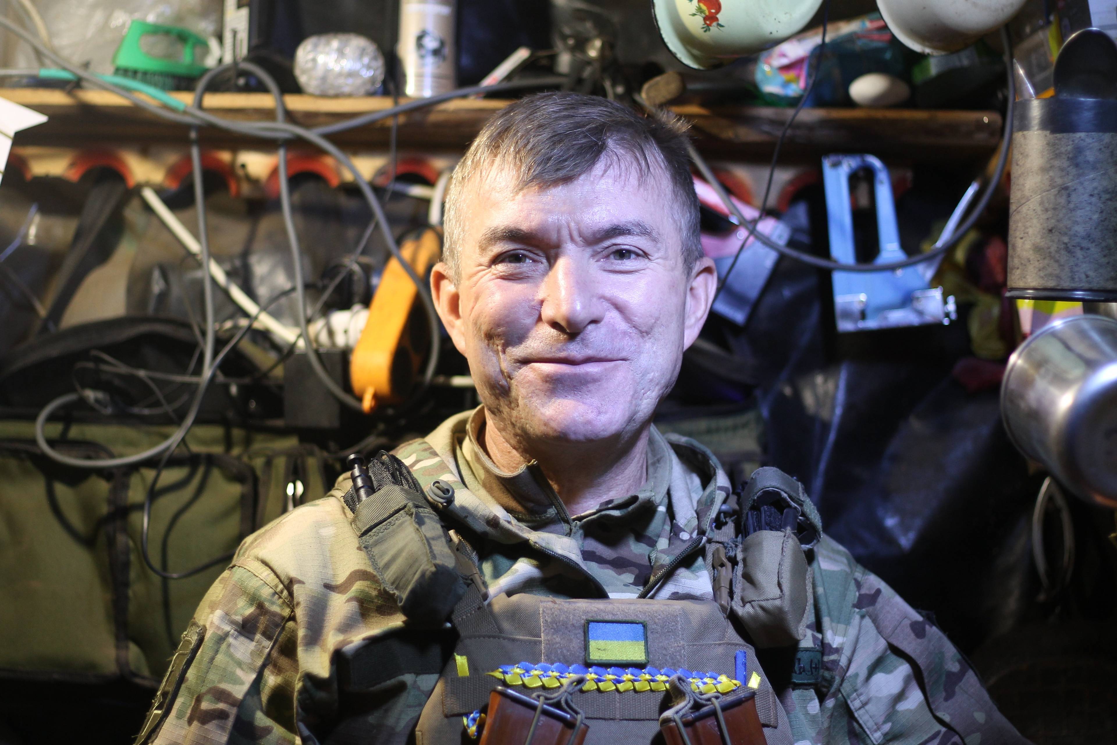 Zdjęcie uśmiechniętego żołnierza we wnętrzu ziemianki