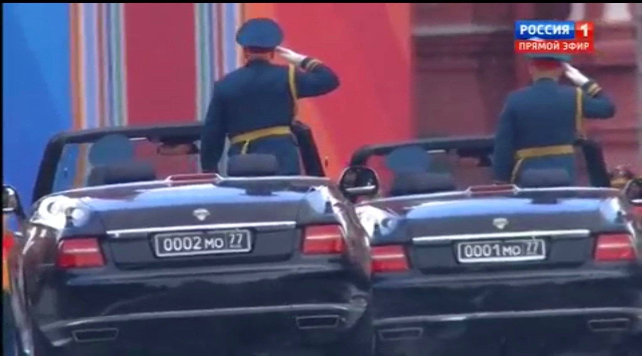 Woskowi przyjmuja paradę jeźdżące wsród żołnierzy w kabrioletach