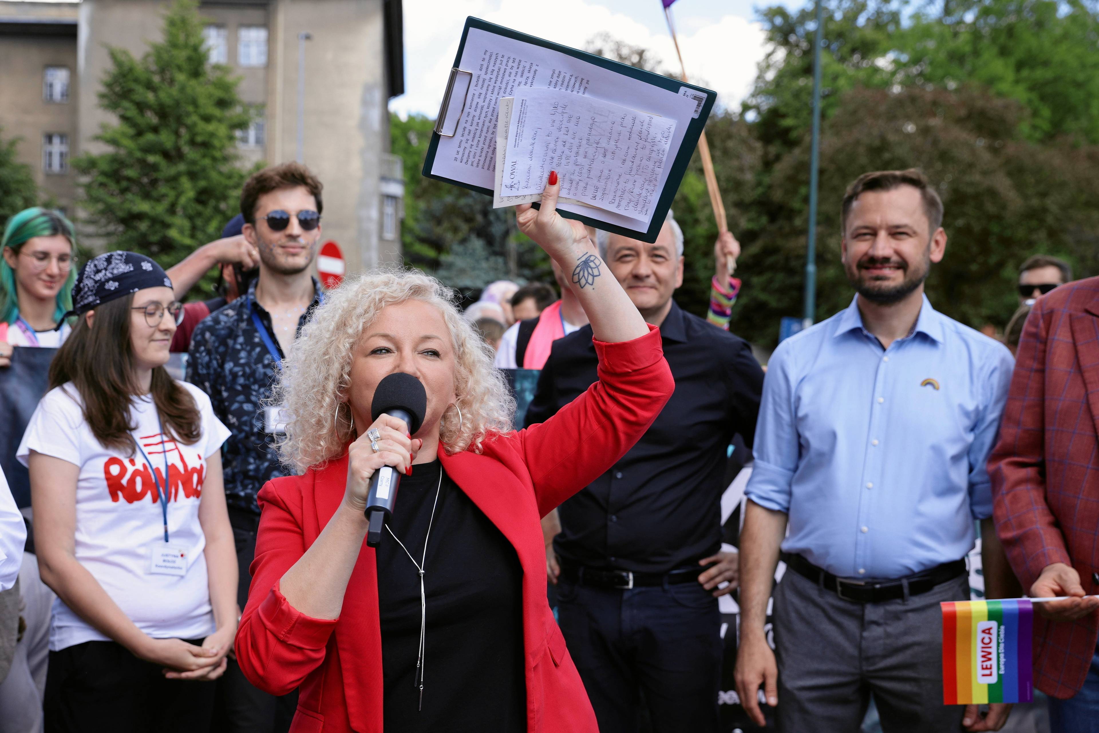 Katarzyna Kotula w czerwonej marynarce przemawia na Marszu Równości