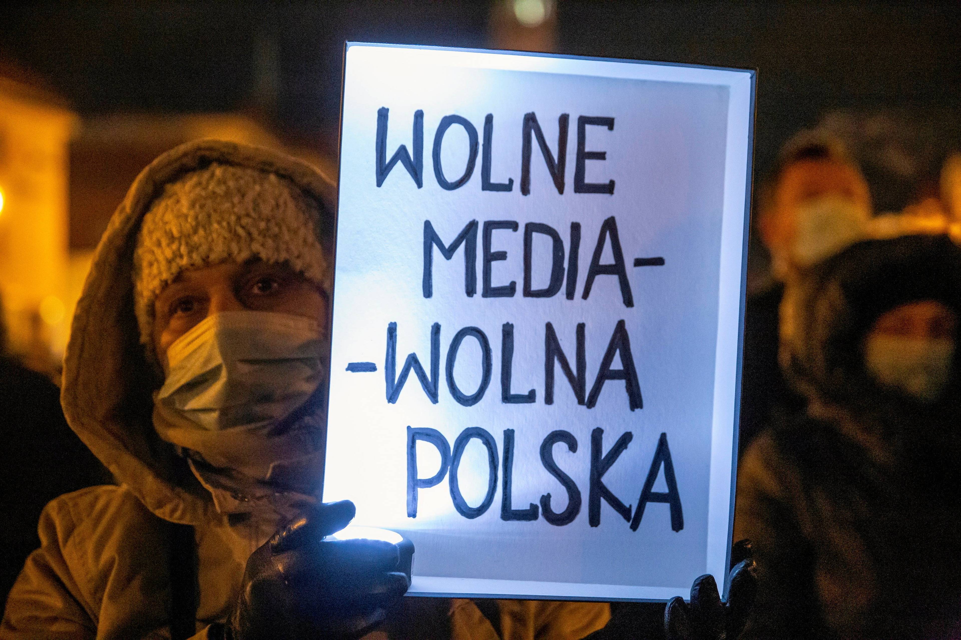 kobieta trzyma kartkę z napisem „Wolne media - wolna Polska"