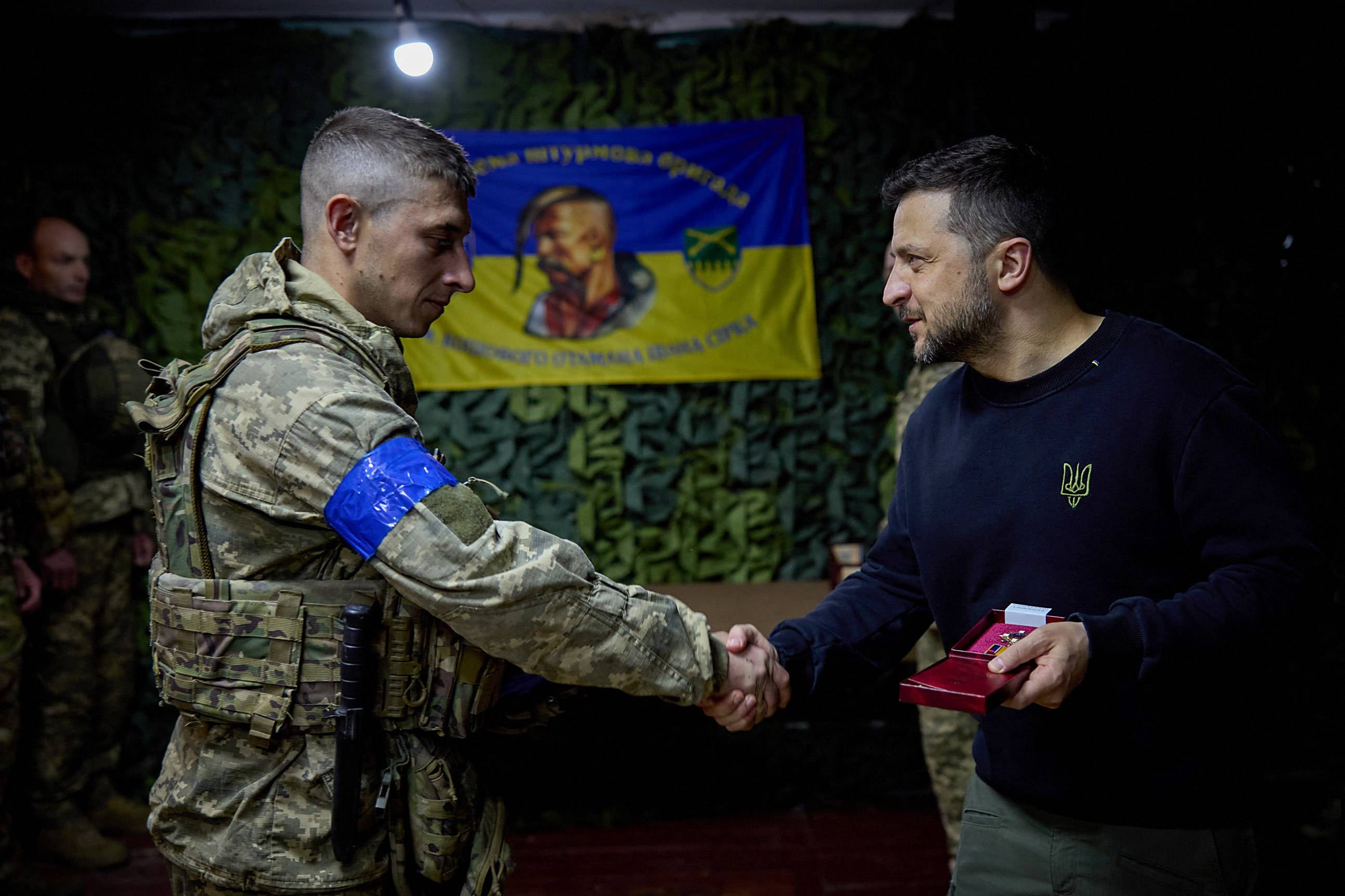 Prezydent Ukrainy Wołodymyr Zełenski ściska rękę ukraińskiego żołnierza. Mobilizacja w Ukrainie