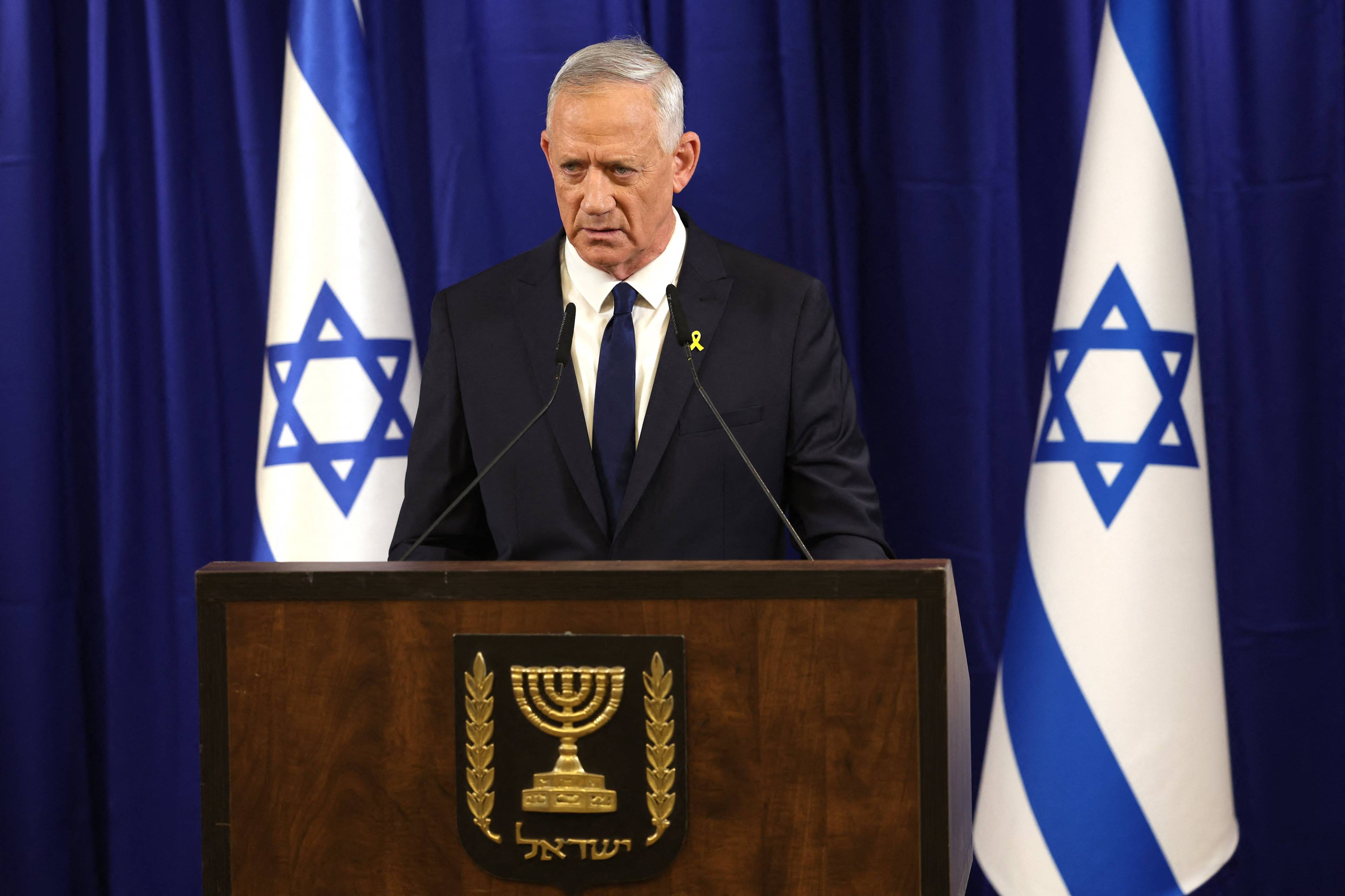 Minister Beni Ganc podczas konferencji, na której ogłosił rezygnację z rządu. W tle flagi Izraela