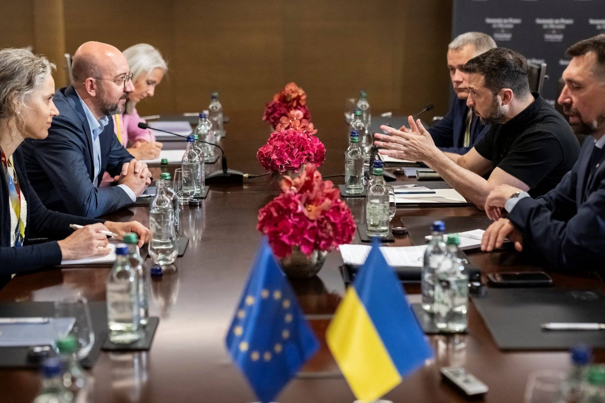 Negocjacje podczas szczytu nt. Ukrainy w Szwajcarii. Za stołem na przeciwko siebie szef Rady Europejskiej Charles Michel i prezydent Ukrainy Wołodymyr Zełenski