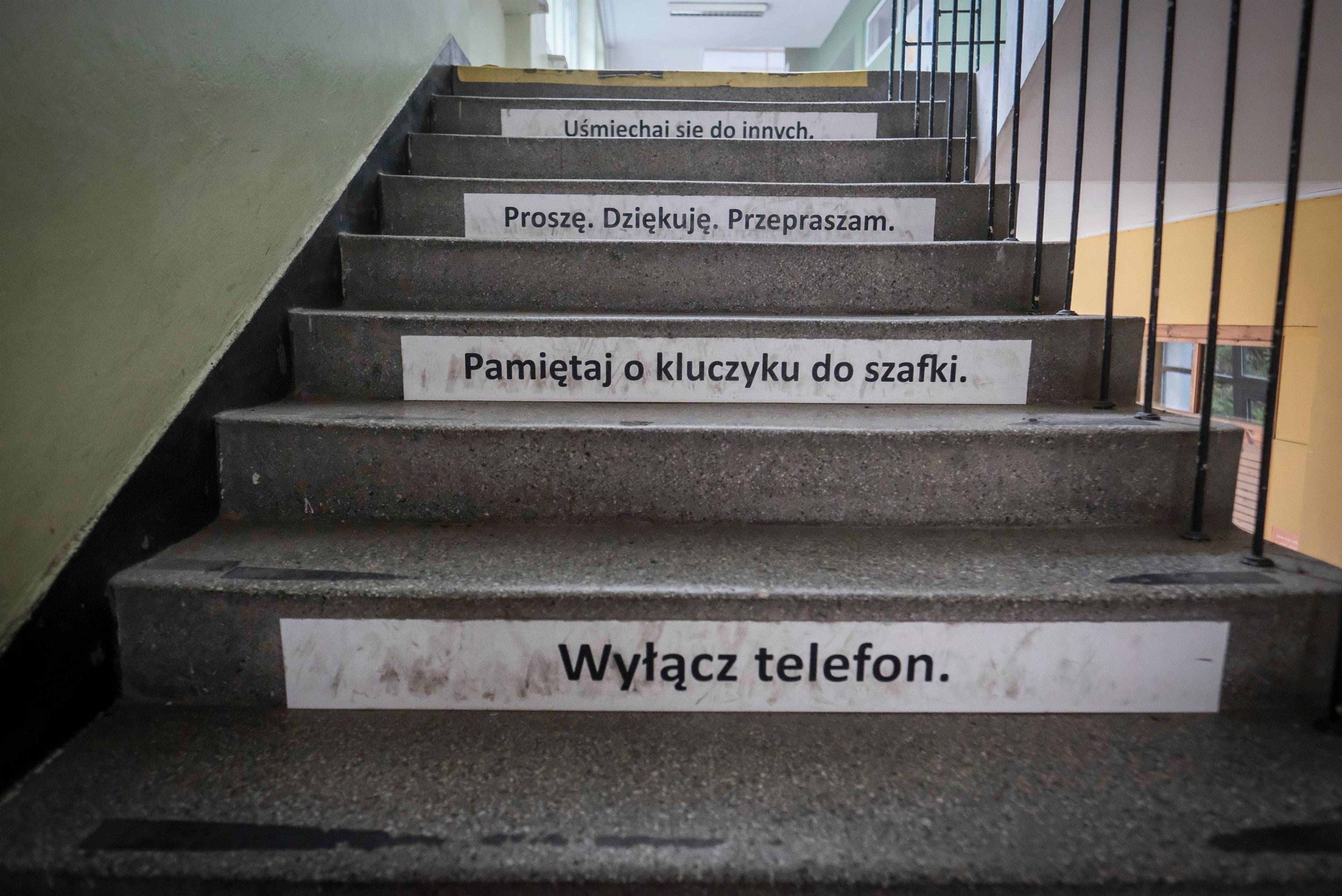 schody z wypisanymi hasłami, m.in. „wyłącz telefon"