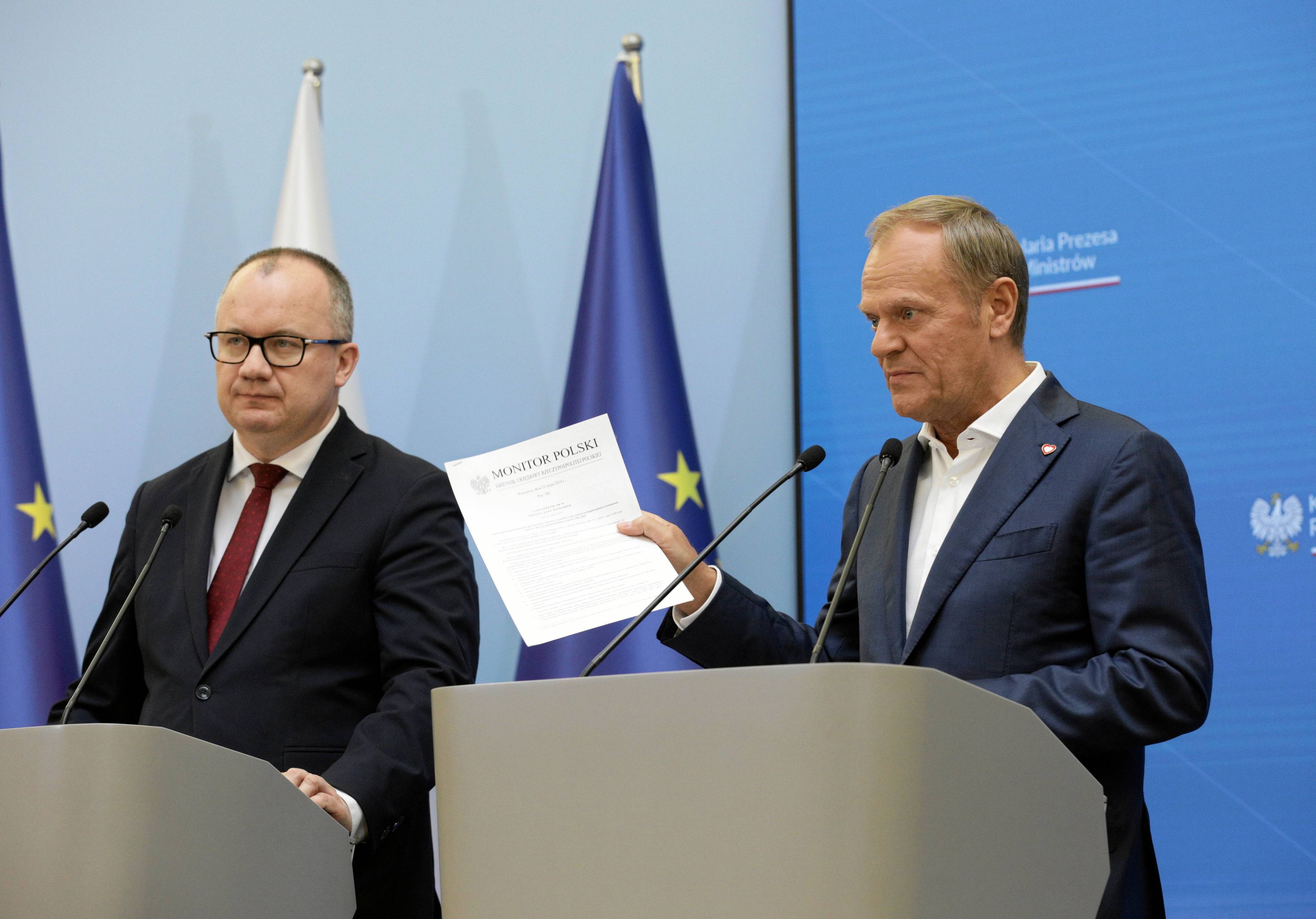 Minister Adam Bodnar i premier Donald Tusk stoją za mówinicami na konferencji prasowej