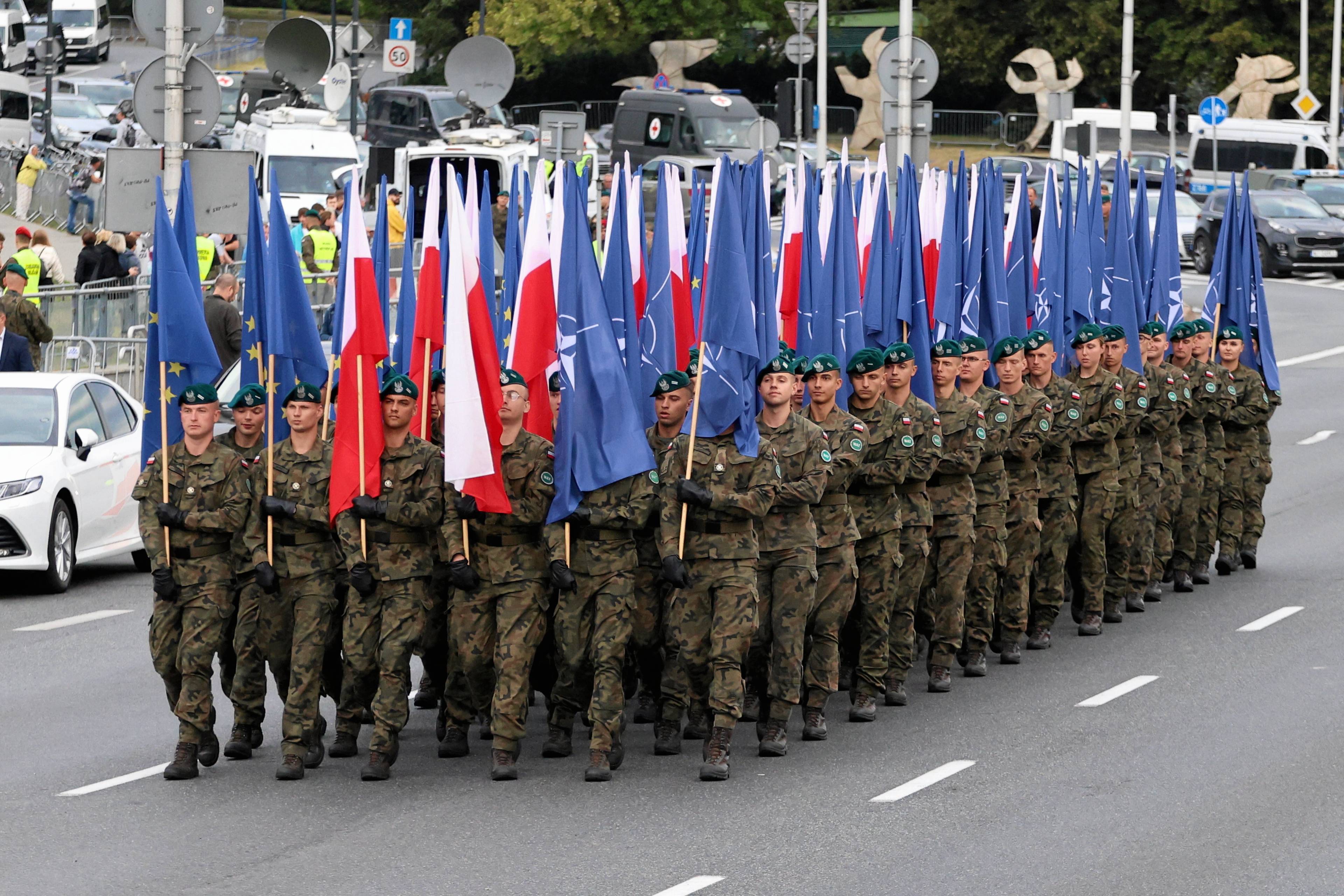 Kolumna wojskowej piechoty z flagami polskimi, Unii Europejskiej i NATO