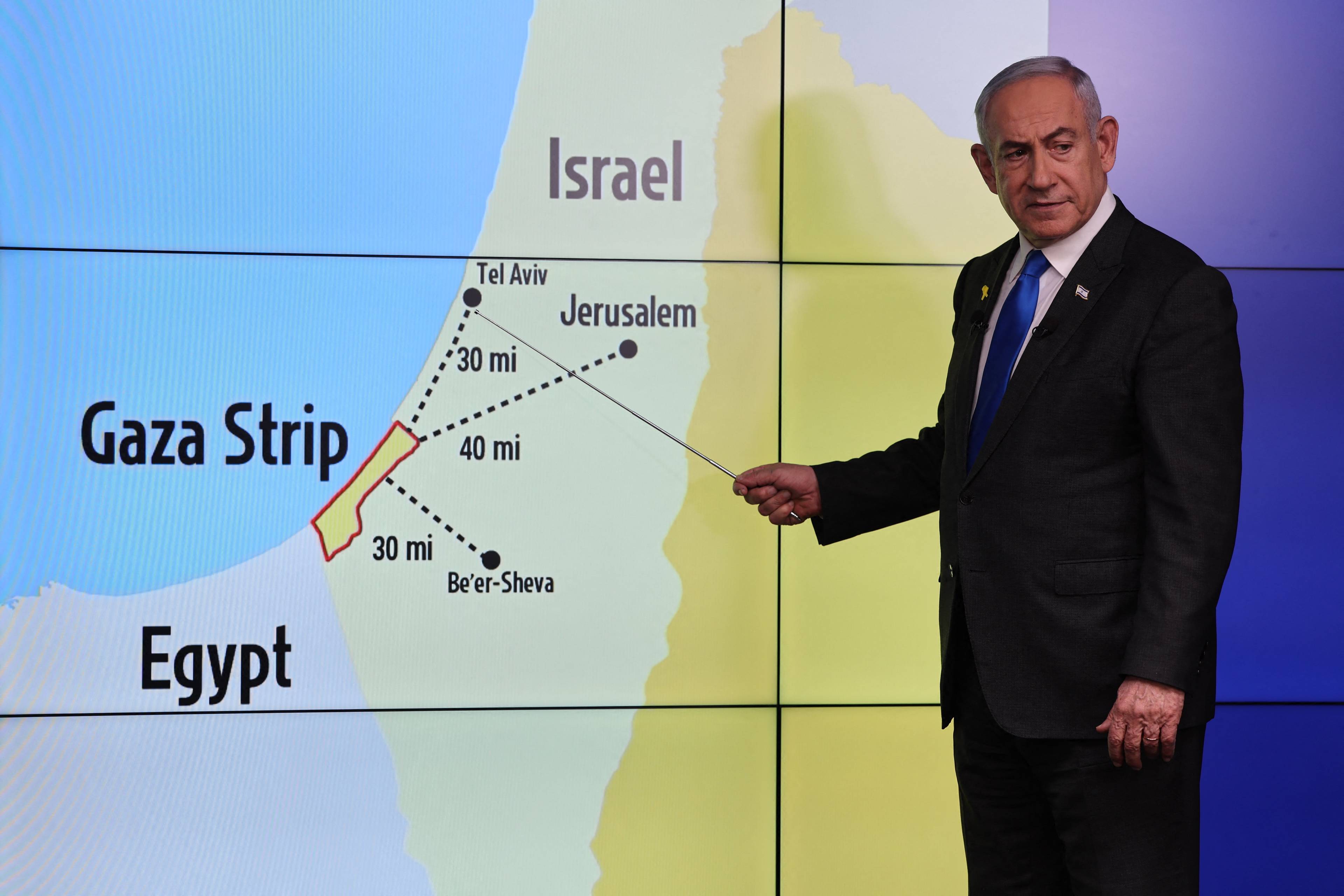 Premier Izraela przed mapą Izraela i Gazy