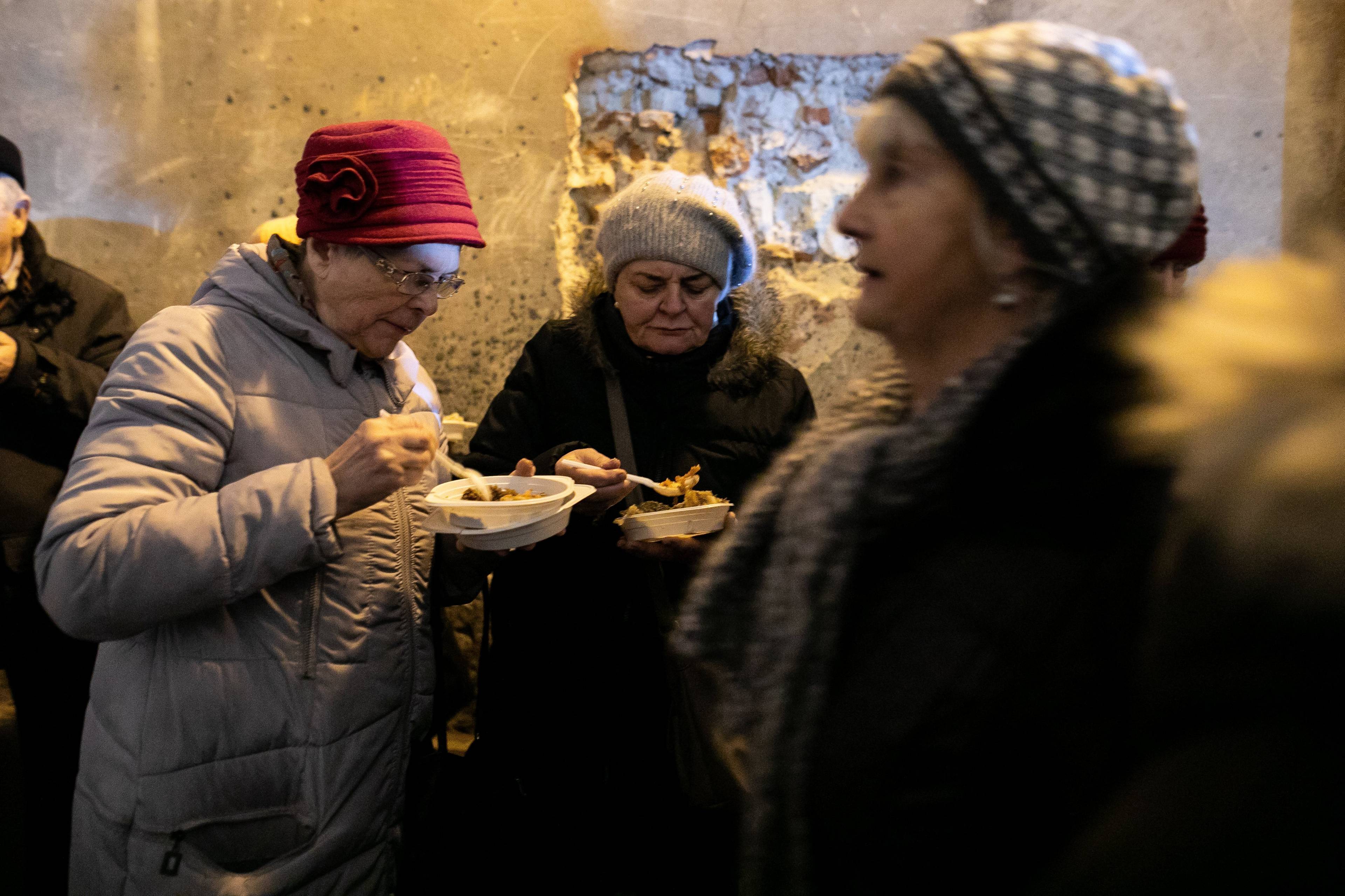 Kobiety jedzą posiłek w ramach wigilii dla ubogich