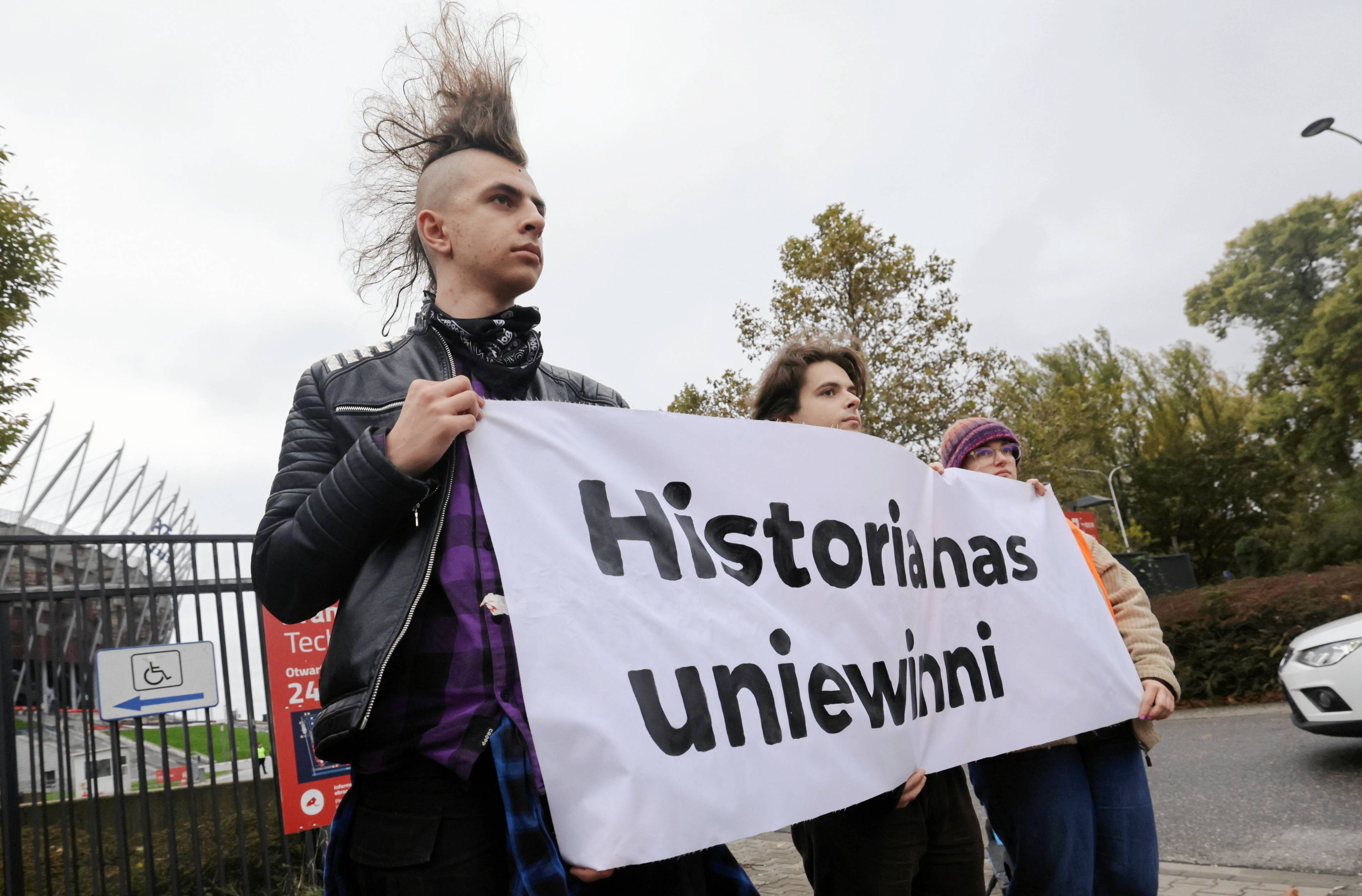 Aktywiści trzymają banaer z napisem "Historia nas uniwinni"