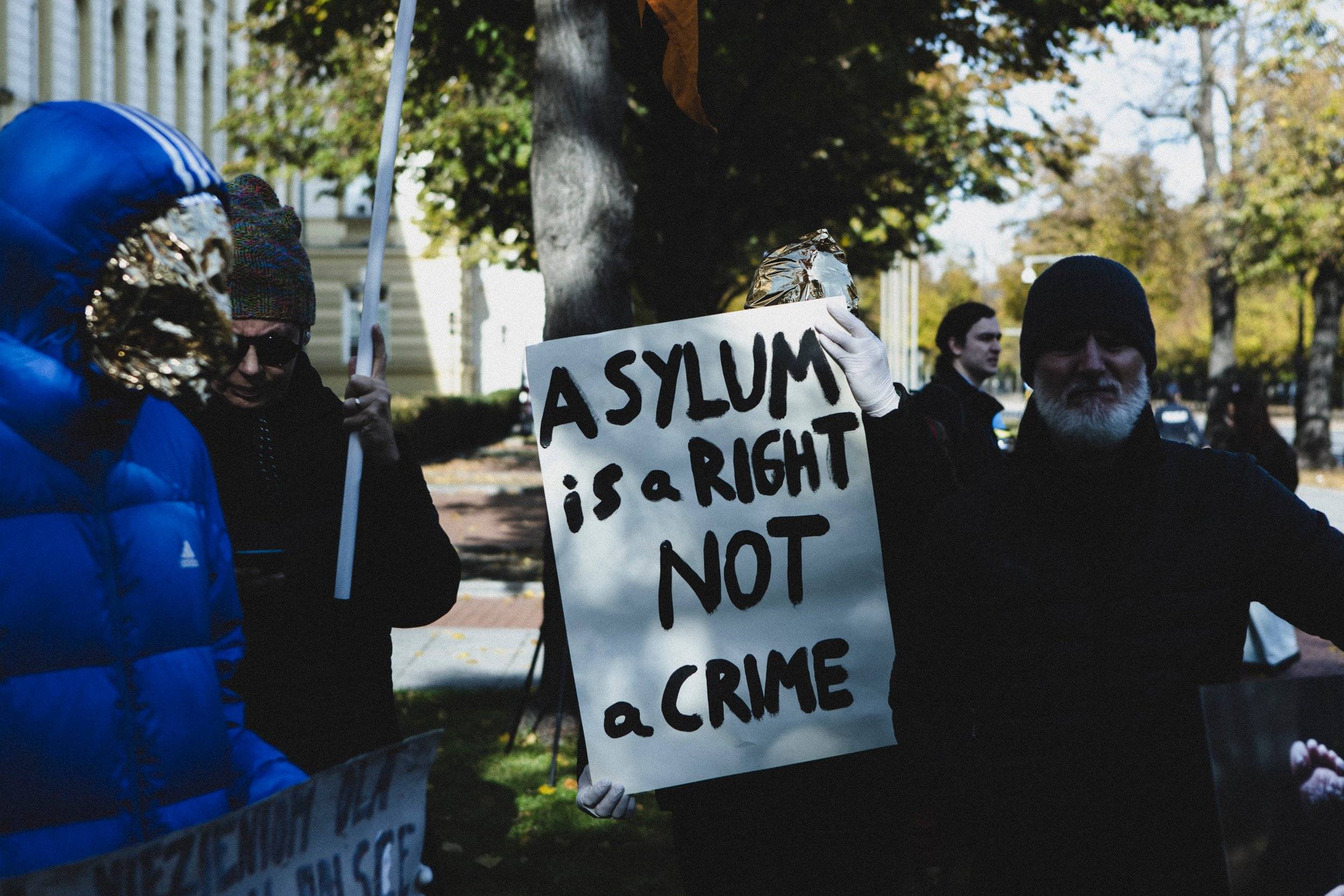 Warszawa 22.10.2024 r. „Azyl, prawo, konstytucja!” Pod taką nazwą została zorganizowana demonstracja pod siedzibą Kancelarii Premiera. W wydarzeniu  wzięło udział kilkadziesiąt osób, wyrażając swój sprzeciw na decyzję Premiera Donalda Tuska o cofnięciu prawa do azylu dla osób uchodźczych.