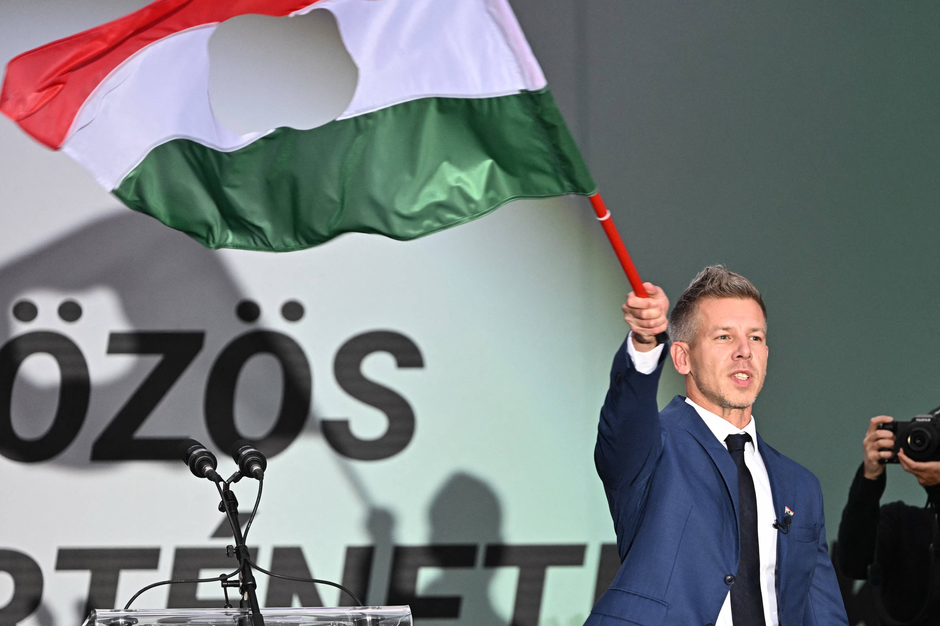 40-latek w garniturze wymachujący wielką czerwono-biało-zieloną flagą
