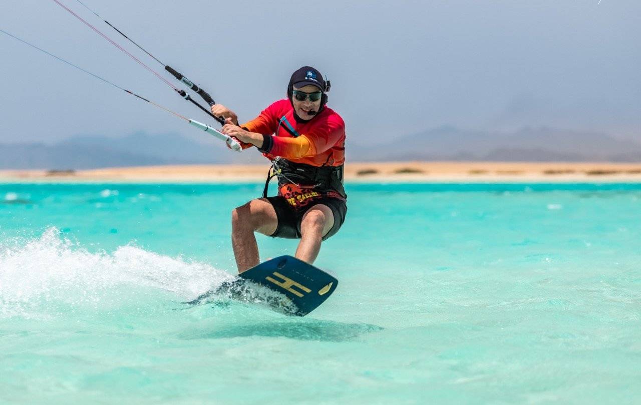 Mężczyzna w ślizgu na desce kitesurfingowej.