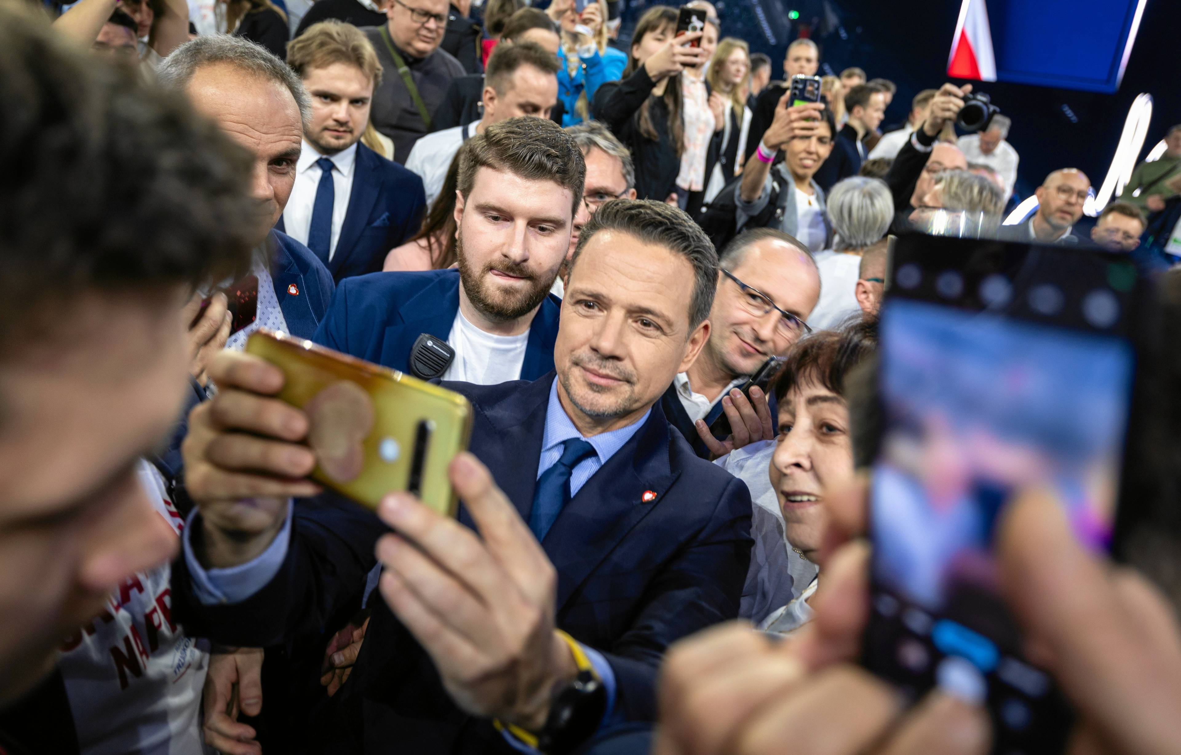 Tłum ludzi, w środku mężczyzna robiący sobie selfi z uiczestnikami wiecu