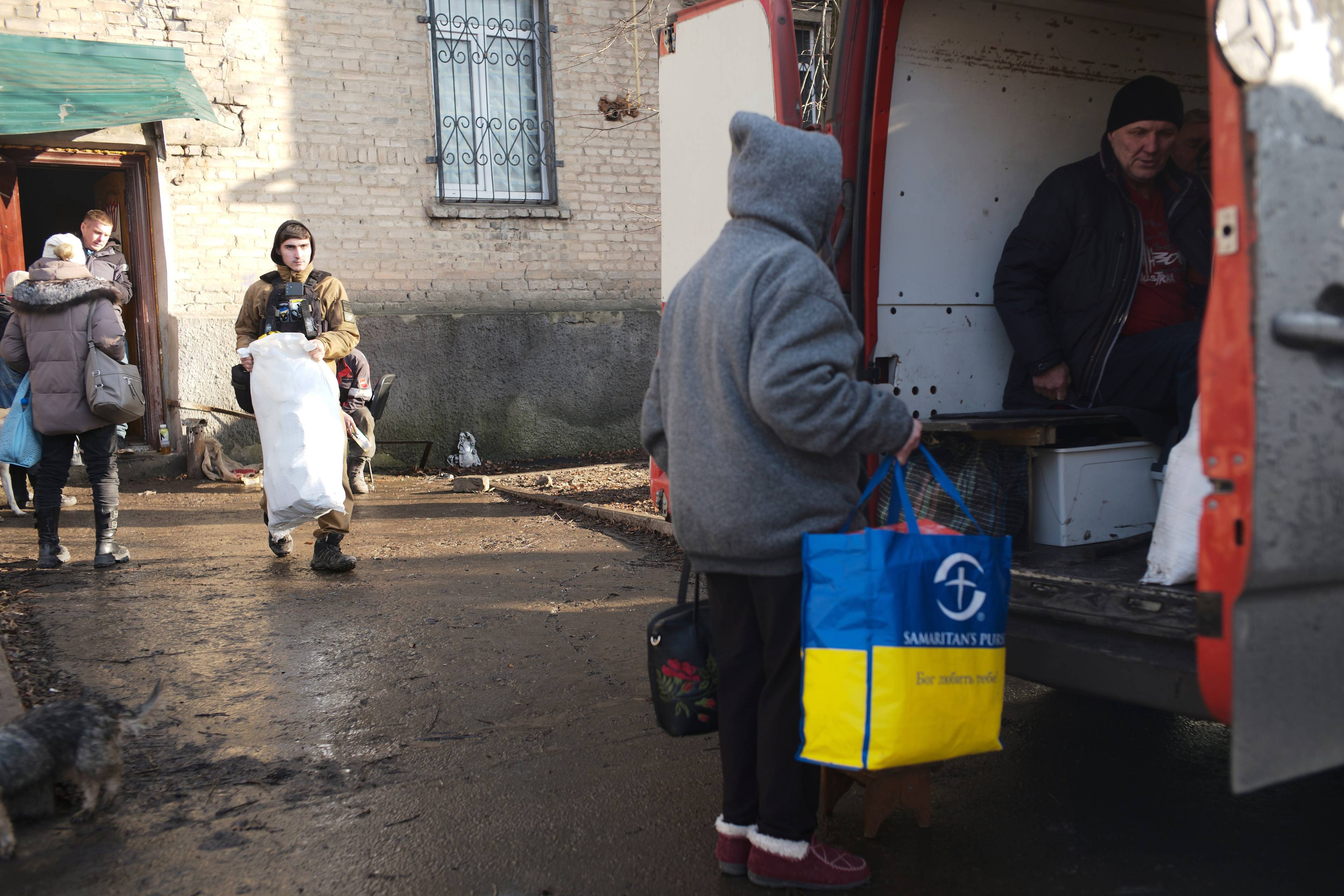 Meżczyżczyzna z torbą w kolorach flagi Ukrainy wsiada do ciężarówki