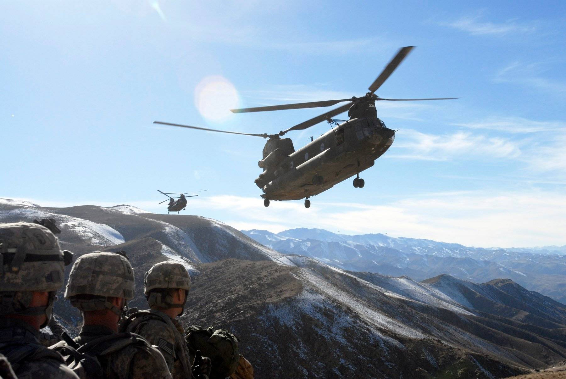 Standing by on a hill top, Soldiers with the 101st Division Special Troops Battalion, 101st Airborne Division watch as two Chinook helicopters fly in to take them back to Bagram Air Field, Afghanistan Nov. 4, 2008.  The Soldiers searched a small village in the valley below for IED making materials and facilities. (Photo by Spc. Mary L. Gonzalez, CJTF-101 Public Affairs)