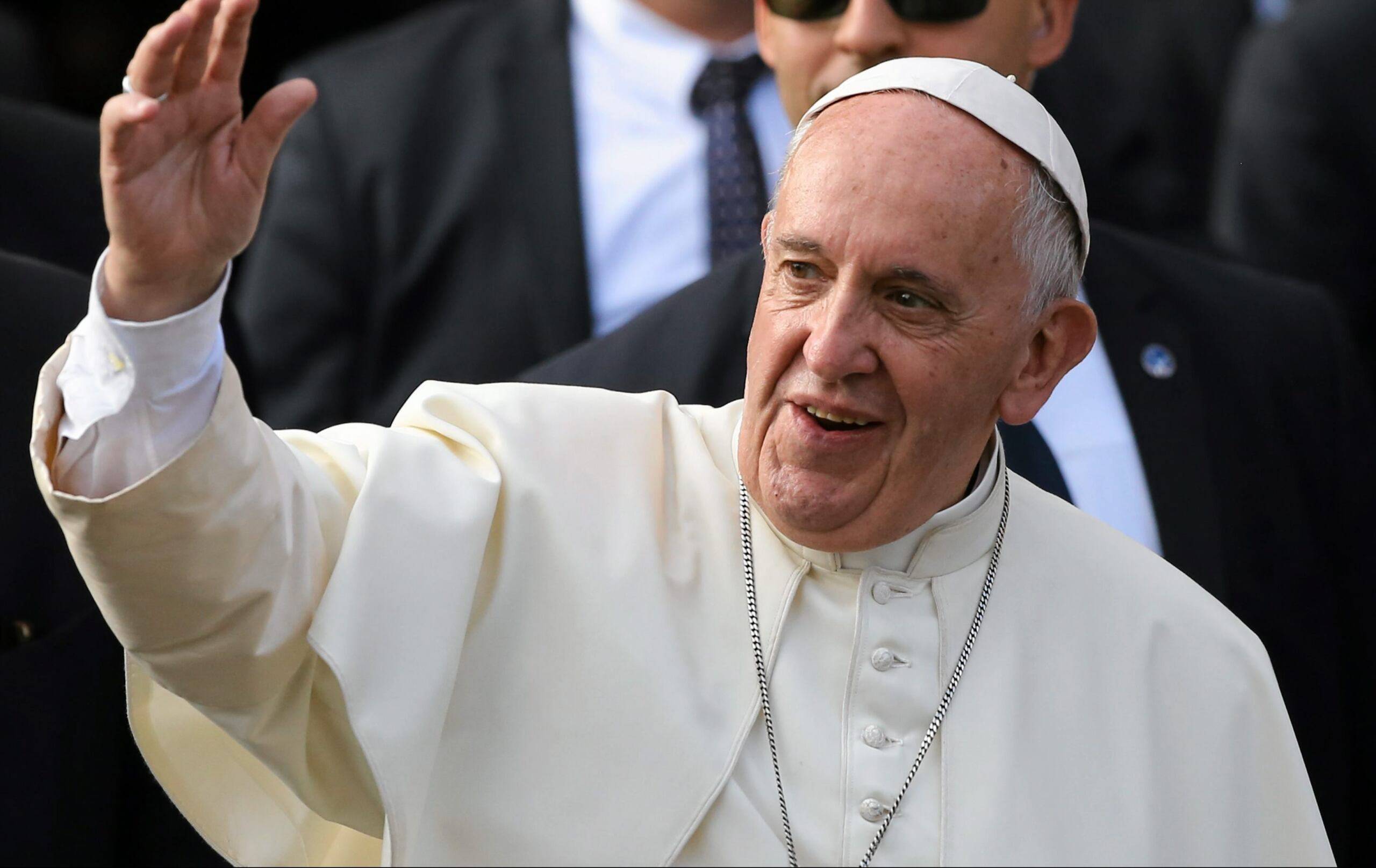 papież Franciszek z uniesioną ręką pozdrawia wiernych