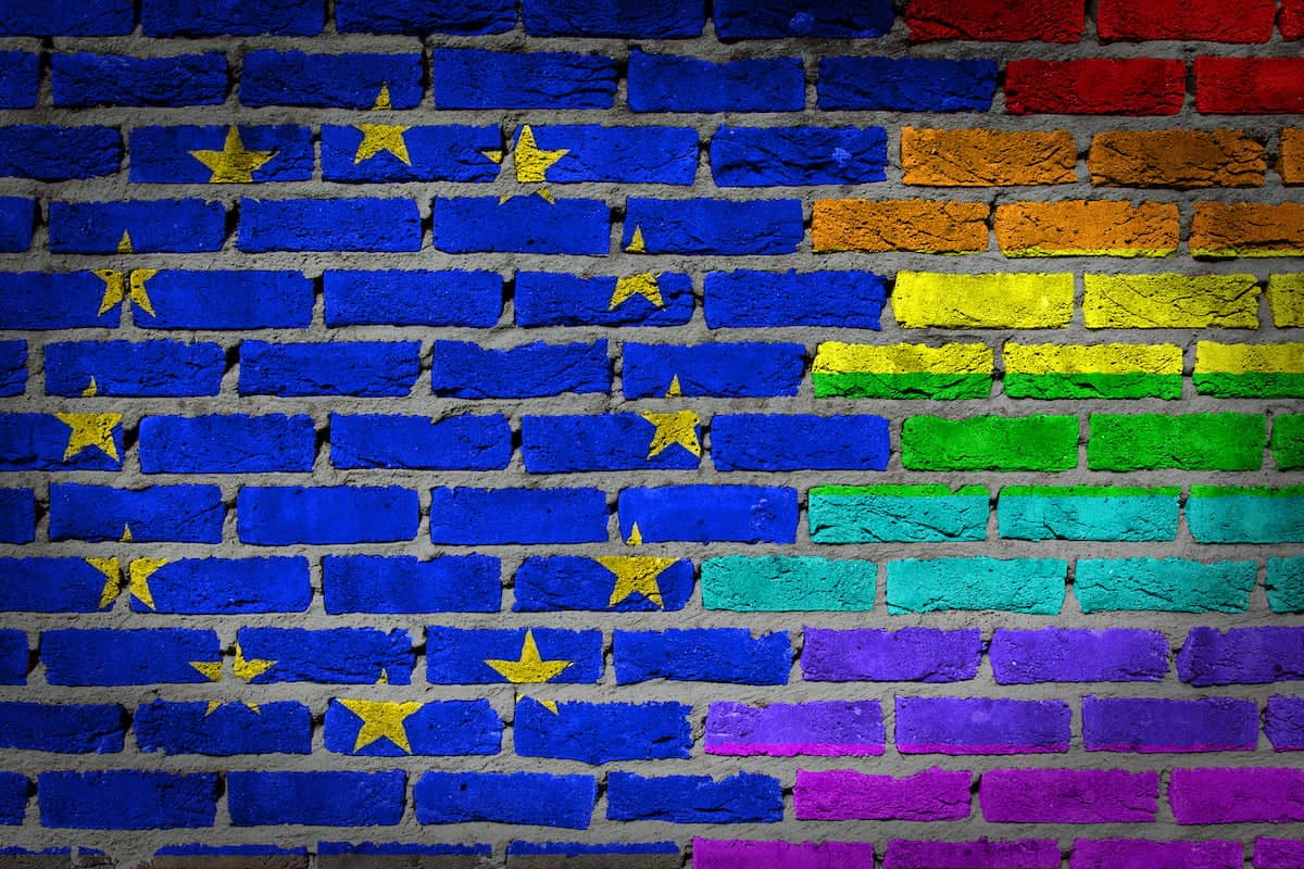 Dark brick wall texture - coutry flag and rainbow flag painted on wall - EU