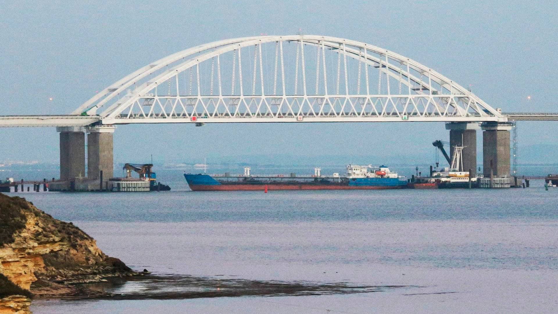 5711849 25.11.2018 A cargo ship blocks a passage under the arch of the Crimean bridge over Kerch Strait in Russia, November 25, 2018. On Sunday Russian authorities closed off the Kerch Strait after three Ukrainian naval ships had crossed the Russian border and entered the temporarily closed area of the Russian territorial waters. Andrej Krylov / Sputnik  via AP