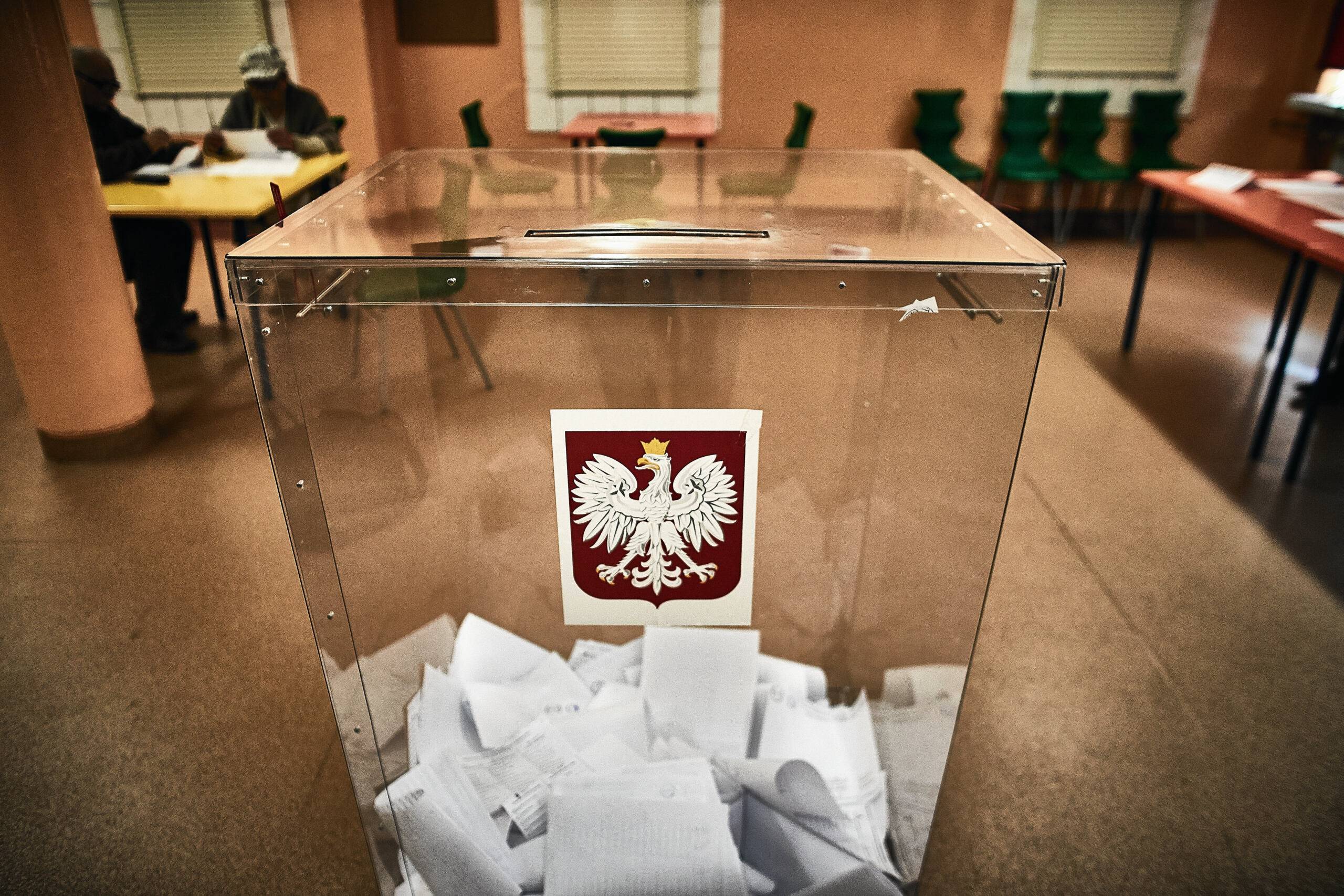 Przezroczysta urna wyborcza wypełniona kartami do głosowania