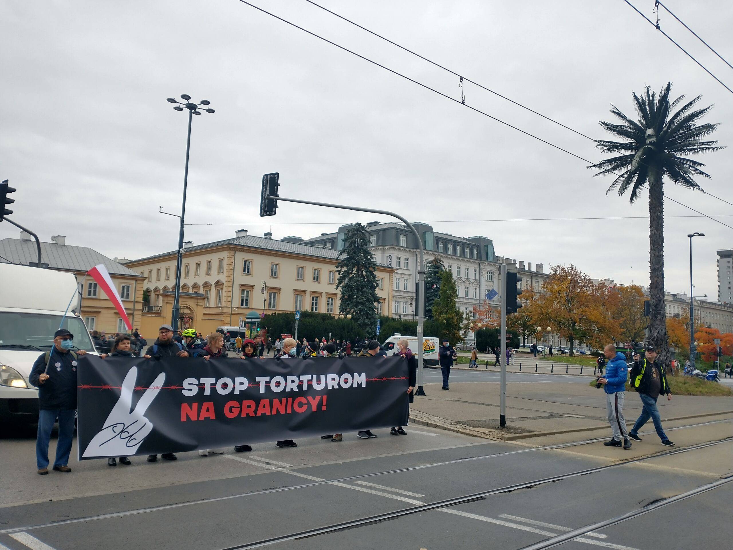 Warszawa. Protest przeciwko działaniom władz na granicy białoruskiej: manifestanci na rondzie De Gaulla z banerem „Stop torturom na granicy"