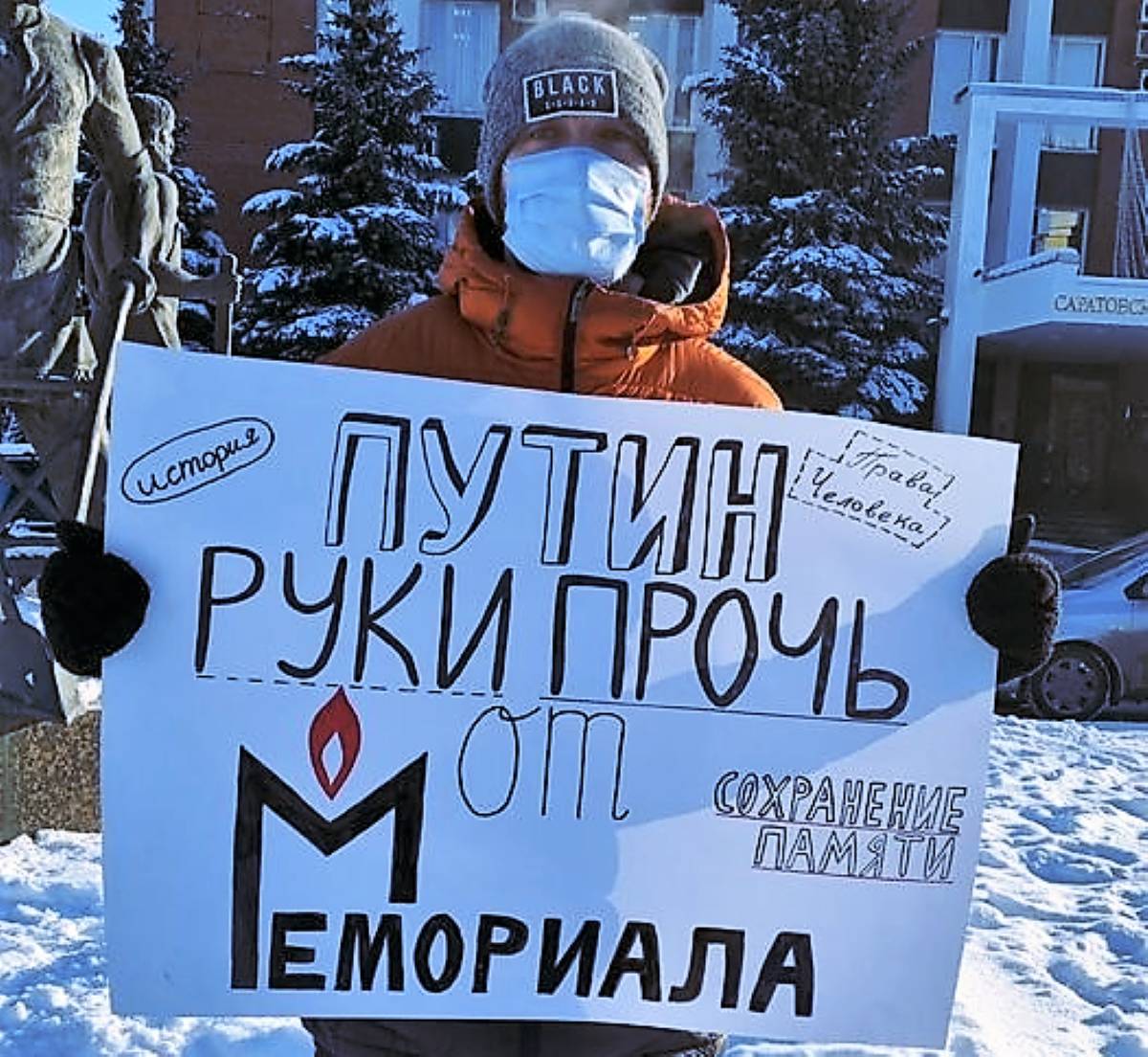 Osoba z plakatem z napisem po rosyjsku Putin ręce precz od Memoriału