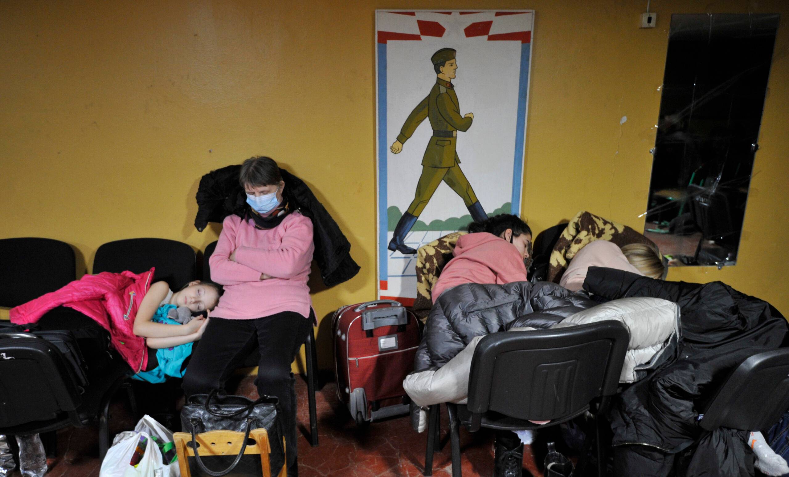 People hide in a bomb shelter in Kyiv in the early hours of February 25, 2022. - Invading Russian forces pressed deep into Ukraine as deadly battles reached the outskirts of Kyiv, with explosions heard in the capital early Friday that the besieged government described as "horrific rocket strikes". The blasts in Kyiv set off a second day of violence after Russian President Vladimir Putin defied Western warnings to unleash a full-scale ground invasion and air assault that quickly claimed dozens of lives and displaced at least 100,000 people. (Photo by Sergei CHUZAVKOV / AFP)